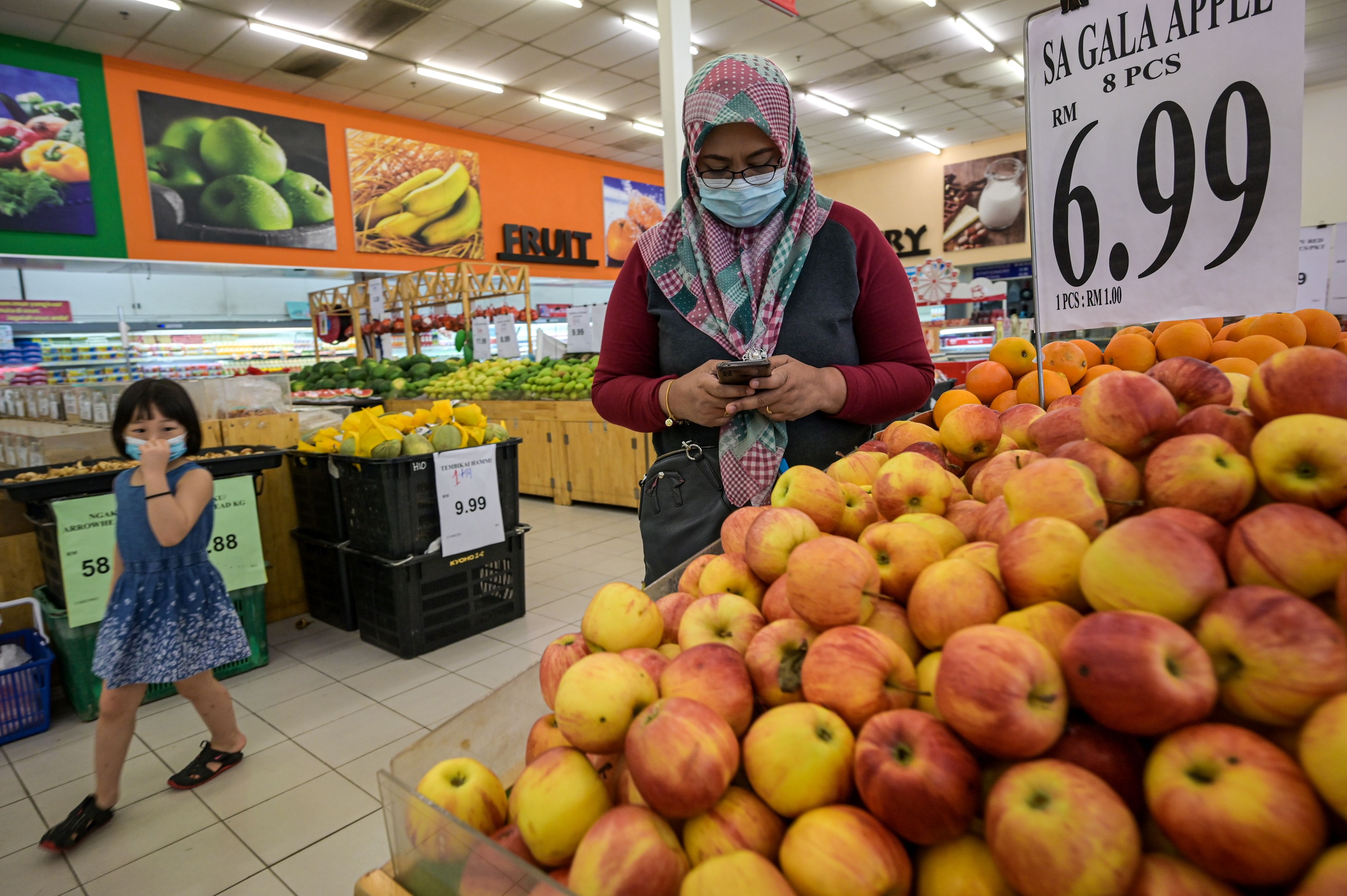 Seorang warga memakai masker saat berbelanja di sebuah supermarket di Bentong, Malaysia.