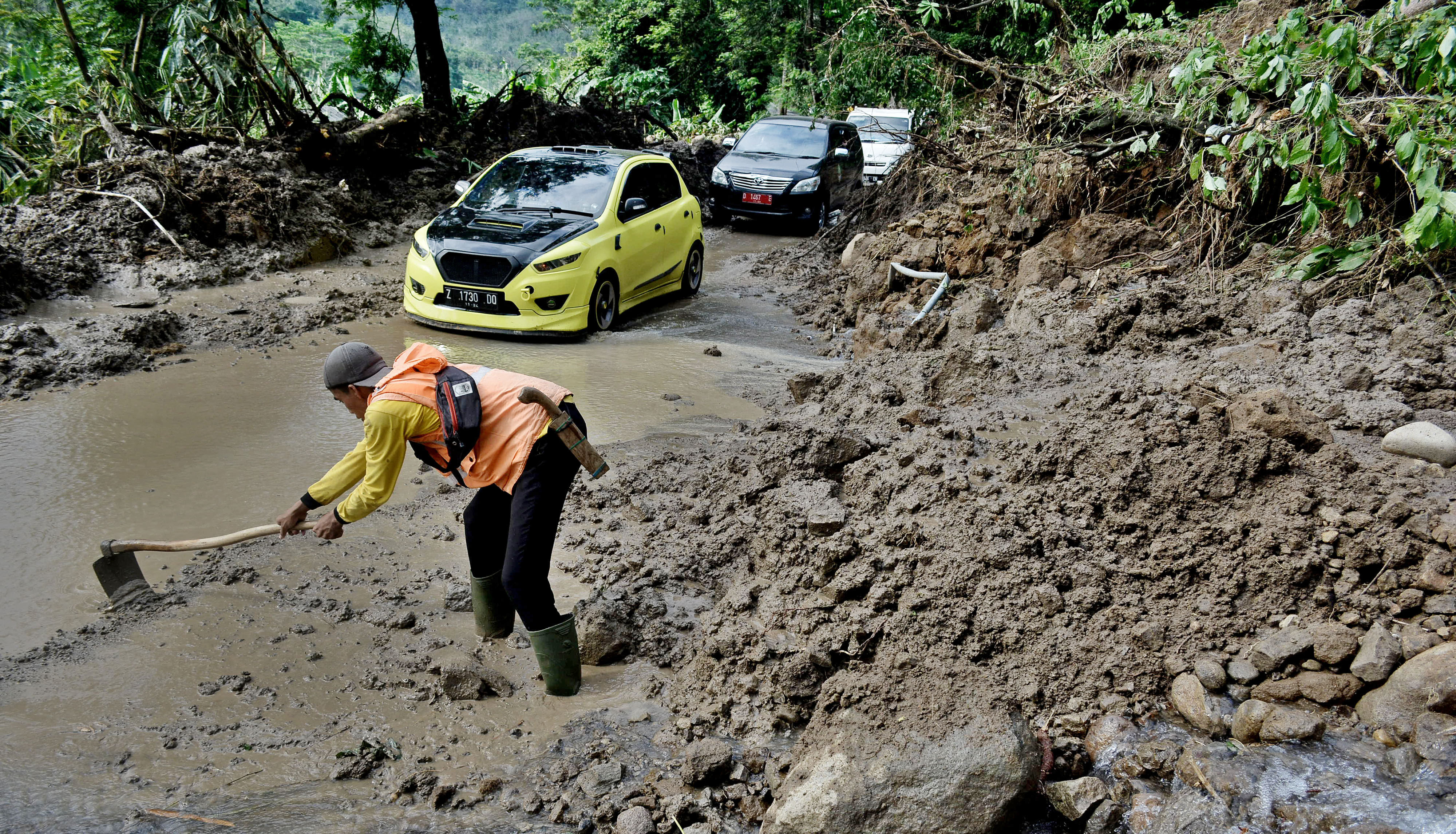 Petugas membersihkan material lumpur dan tanah di Desa Sirnabakti, Pameungpeuk, Kabupaten Garut, Jawa Barat, Senin (12/10/2020).