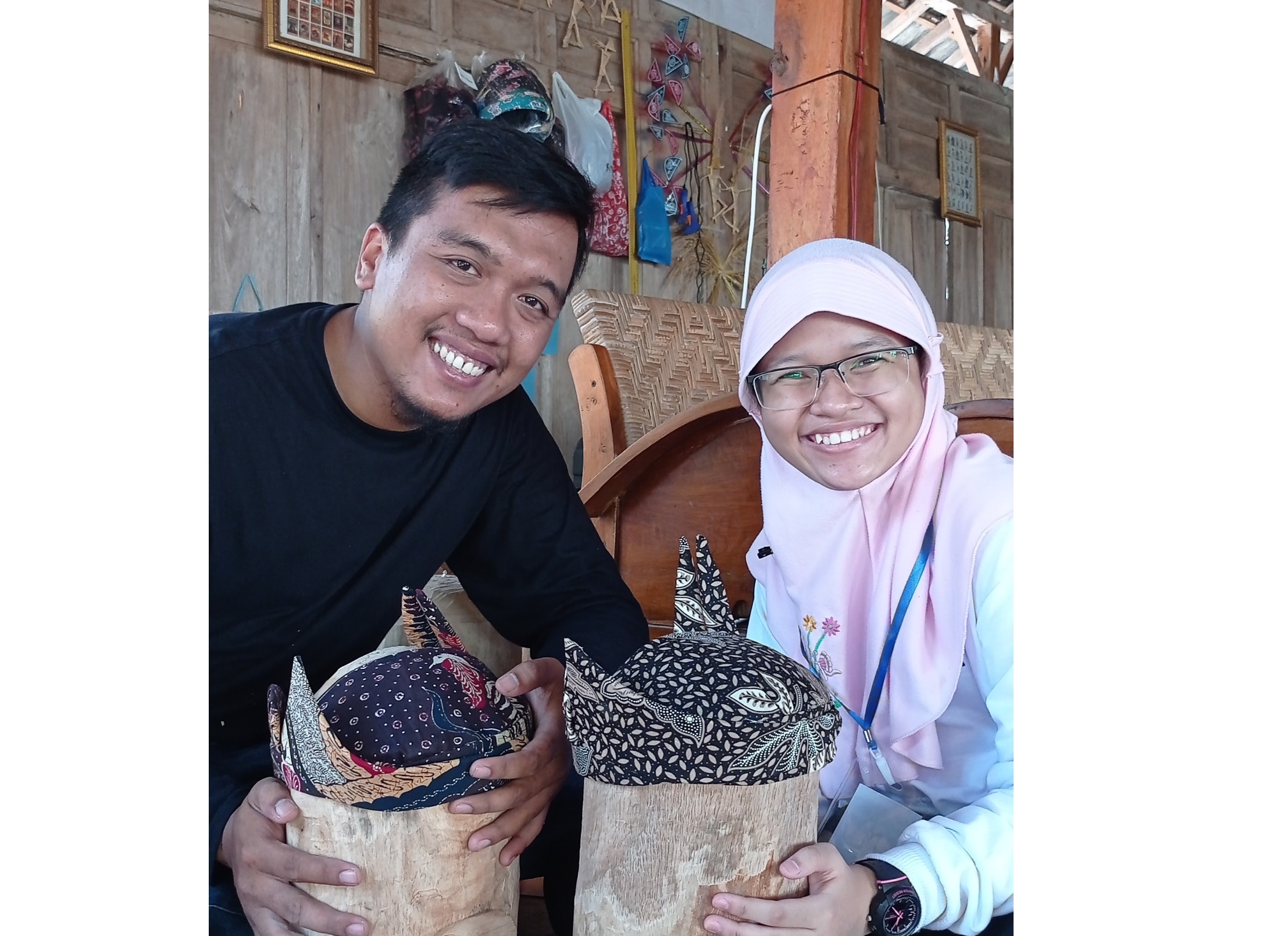 Penulis (kanan) bersama Kak Fandi menunjukkan ikat kepala tradisional Sidoarjo yang bernama udeng pacul gowang.