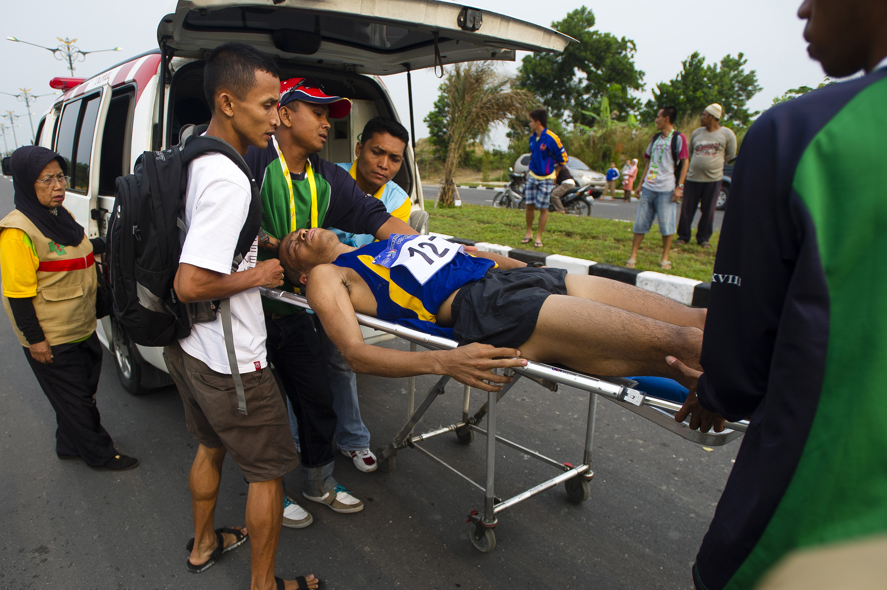 Sejumlah petugas medis mengevakuasi seorang yang tidak sadarkan diri karena kelelahan saat berlaga di ajang PON XVIII Riau.