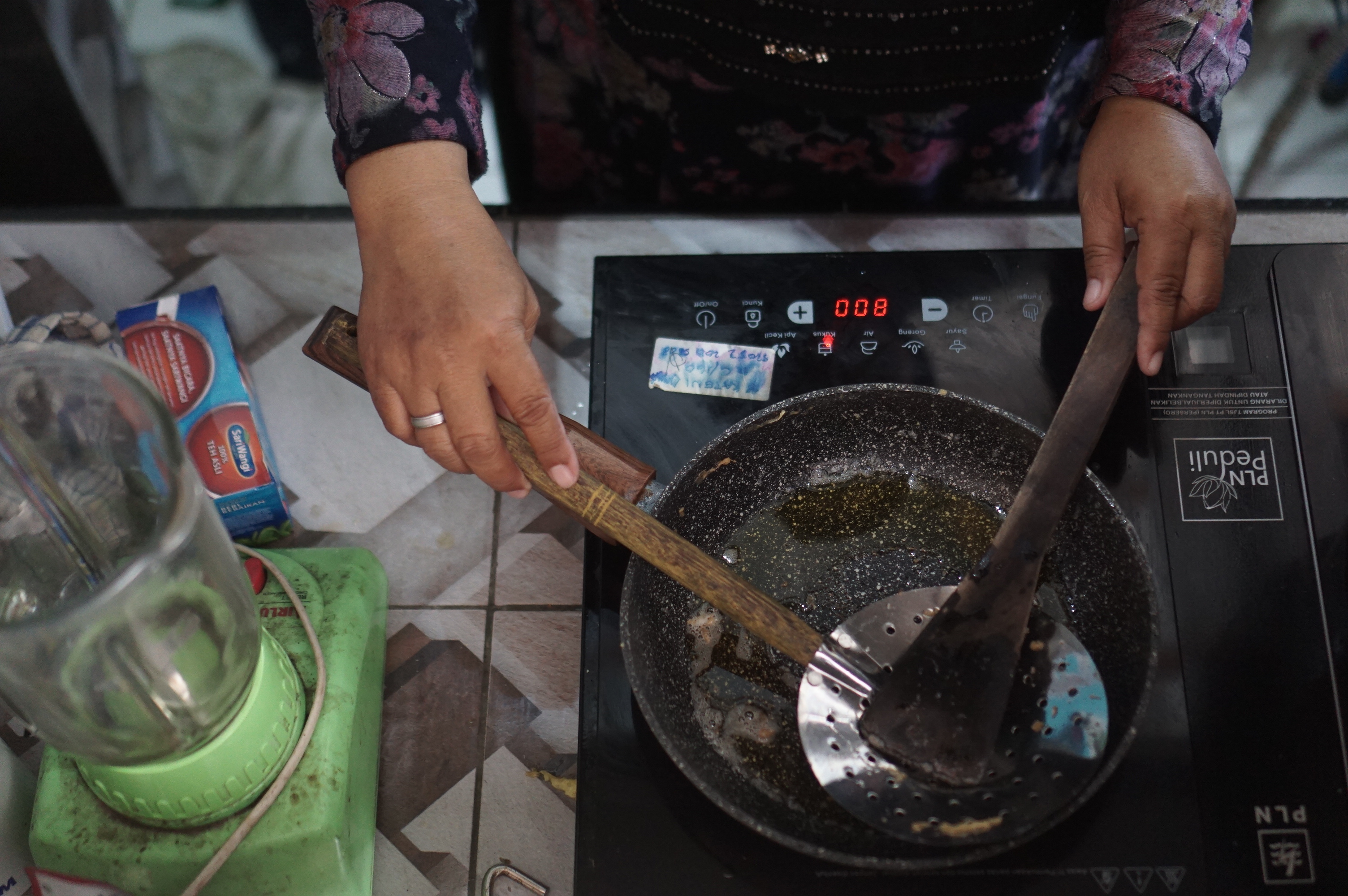 Warga memasak menggunakan kompor listrik induksi di Kampung Mojo, Semanggi, Solo, Jawa Tengah.