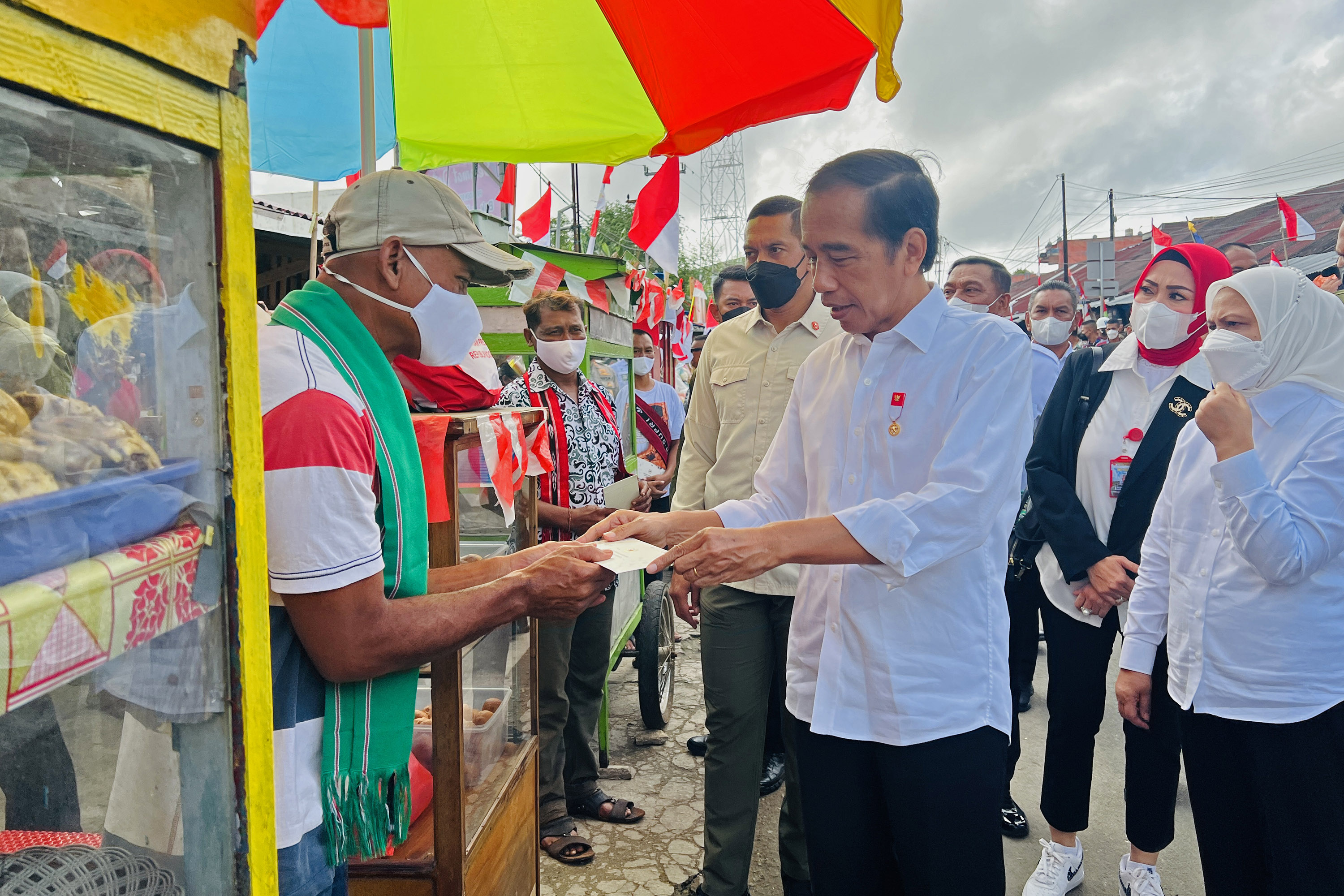 Presiden Jokowi memberikan bantuan kepada pedagang saat mengunjungi wilayah Tanimbar Selatan, Maluku.