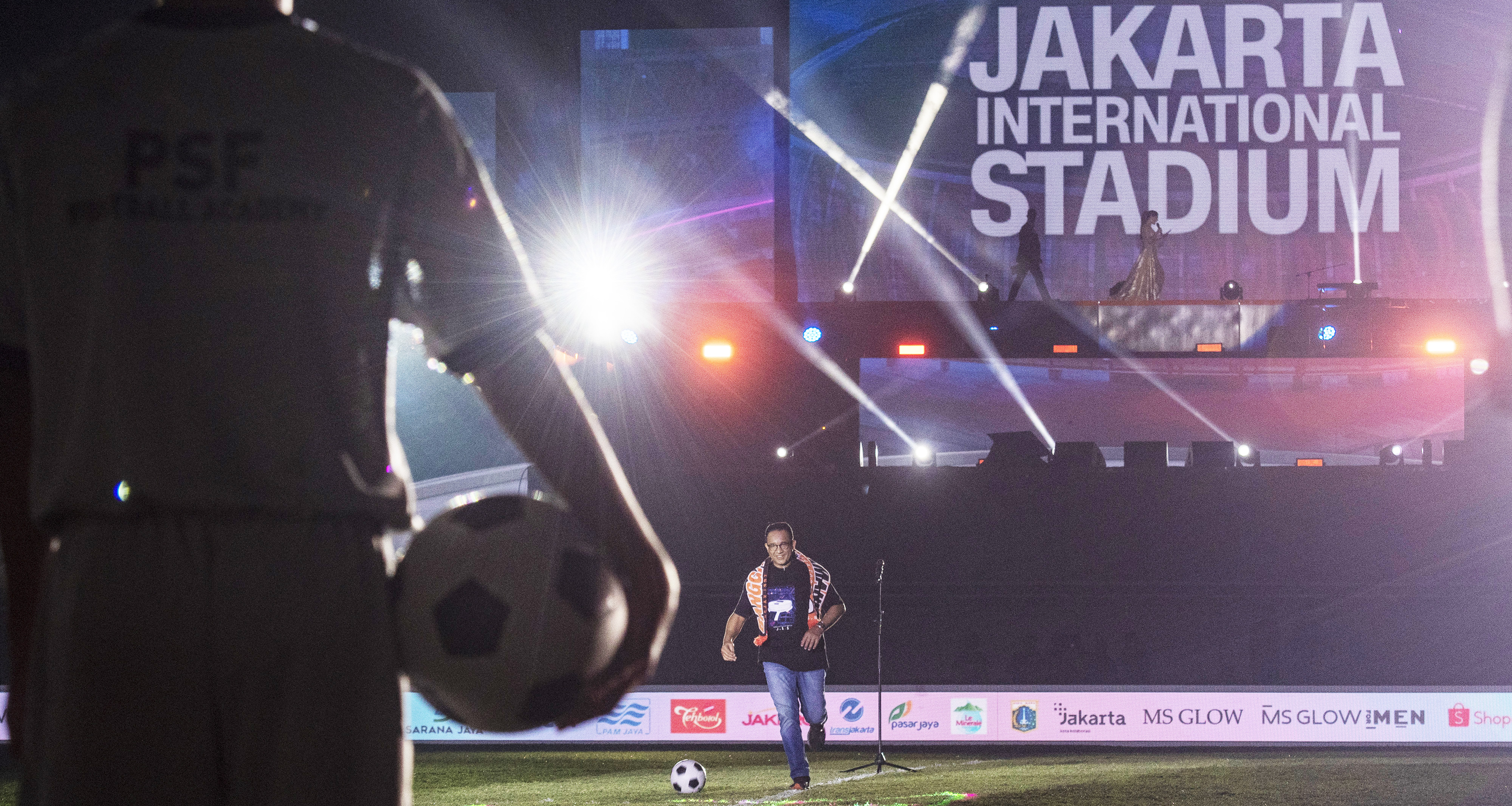 Gubernur DKI Jakarta Anies Baswedan berlari mengiring bola saat meresmikan Stadion Jakarta International Stadium (JIS) di Jakarta, Minggu( 2