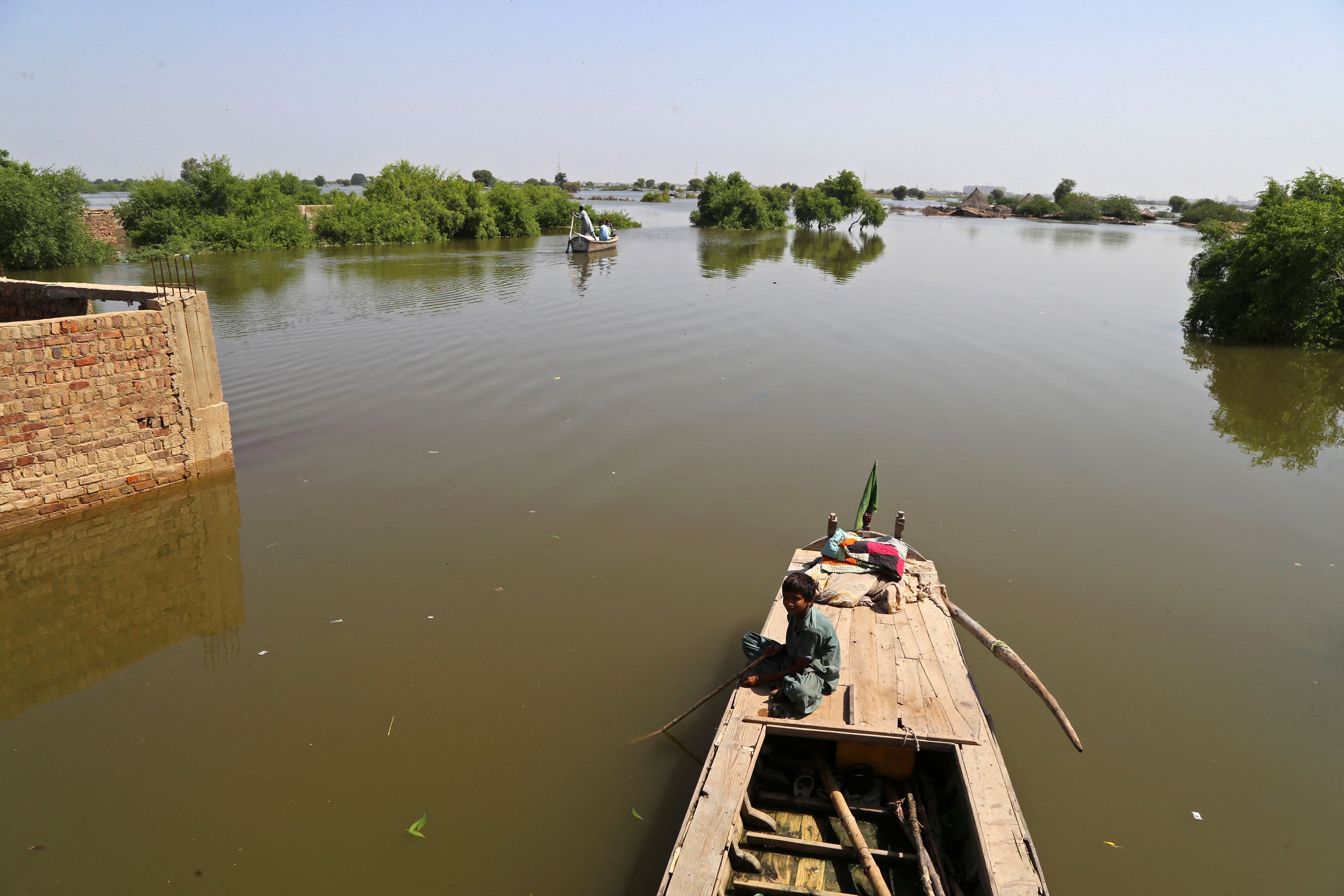 Seorang bocah duduk di atas perahu akibat luapan air yang membanjiri Jamshoro, kota di Hyderabad, Provinsi Sindh, Pakistan, Selasa (6/9).
