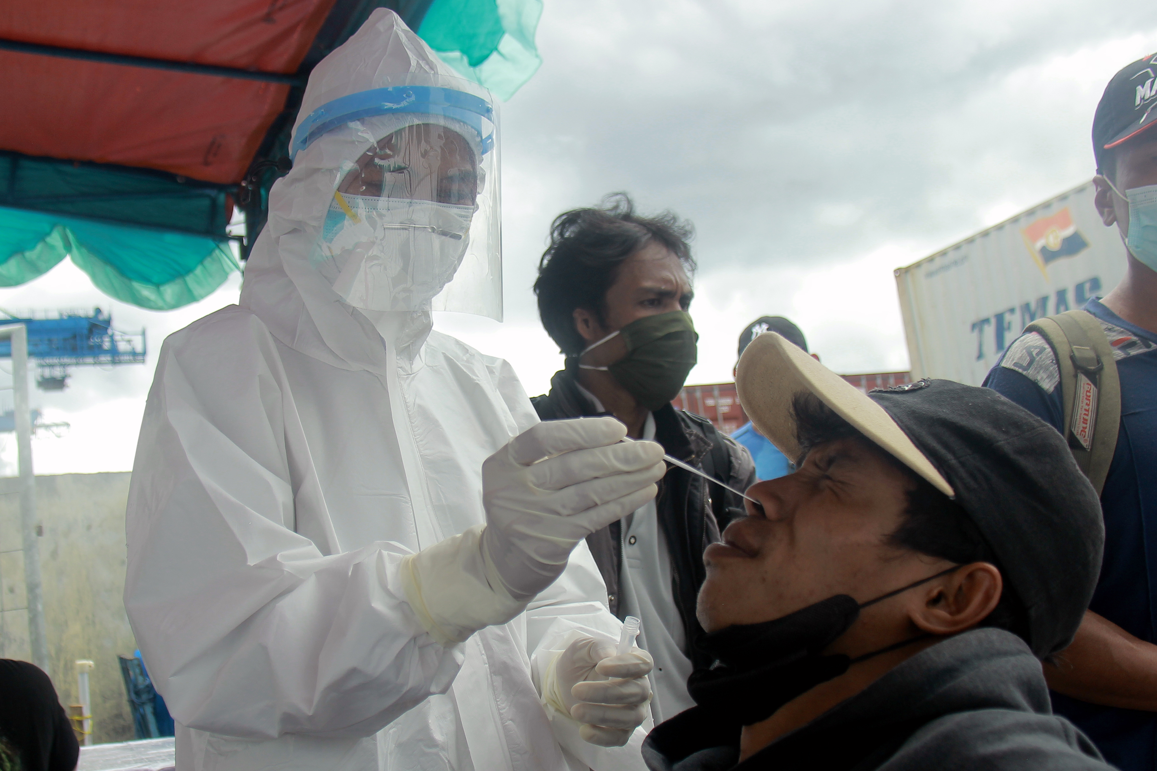  Seorang tenaga medis melakukan tes antigen kepada penumpang KM Sinabung yang baru tiba di Pelabuhan Ternate, Maluku, Senin (21/2).
