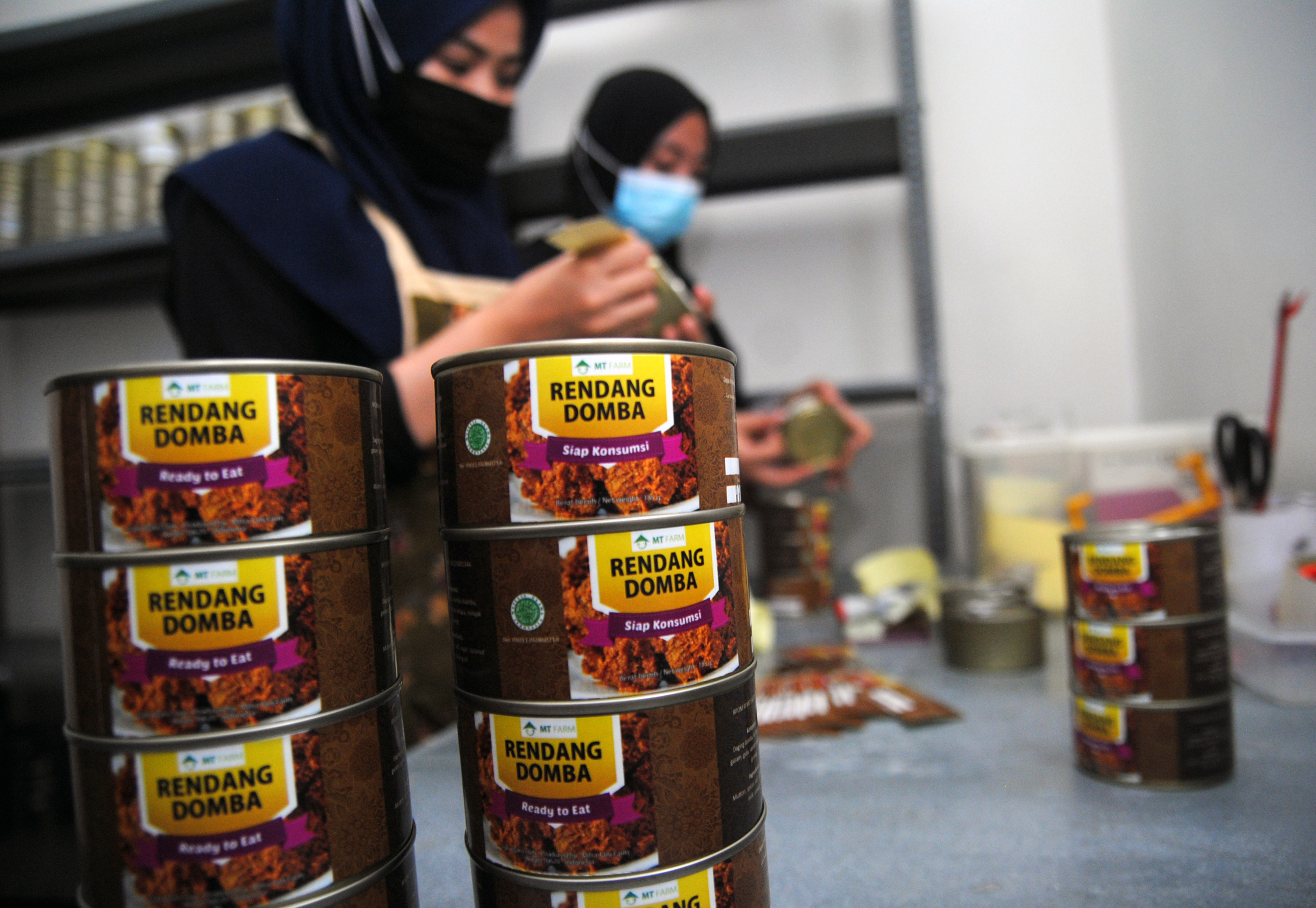 Pekerja memasang label pada olahan daging domba dalam kemasan kaleng saat proses produksi di Mitra Tani (MT) Farm, Jawa Barat.