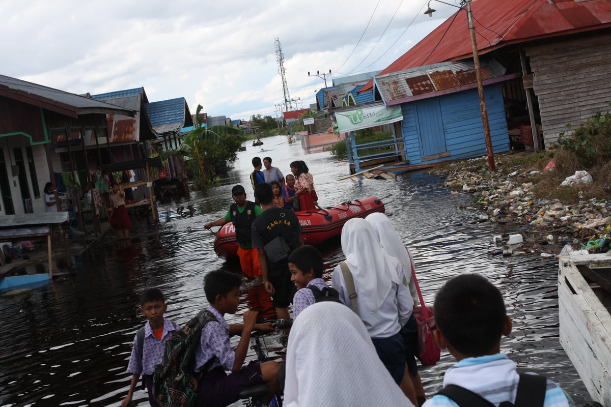 Sejumlah siswa mengantri perahu karet milik Dinsos Kalteng untuk pulang ke rumah mereka yang kebanjiran di Jl.Arut, Palangkaraya, Kalteng.
