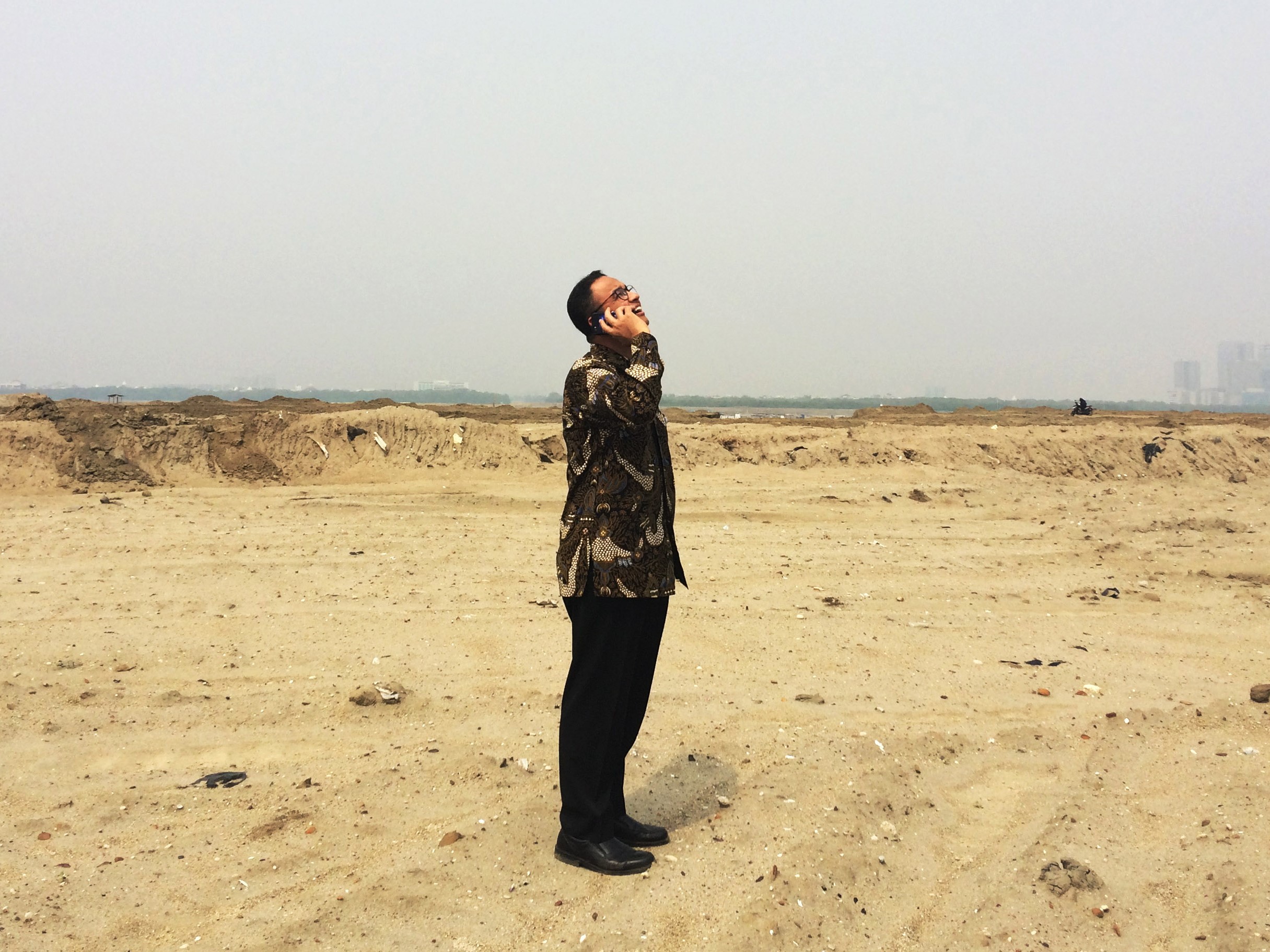 Gubernur DKI Jakarta Anies Baswedan berbicara dengan menggunakan telepon seluler saat untuk pertama kali mengunjungi proyek reklamasi.