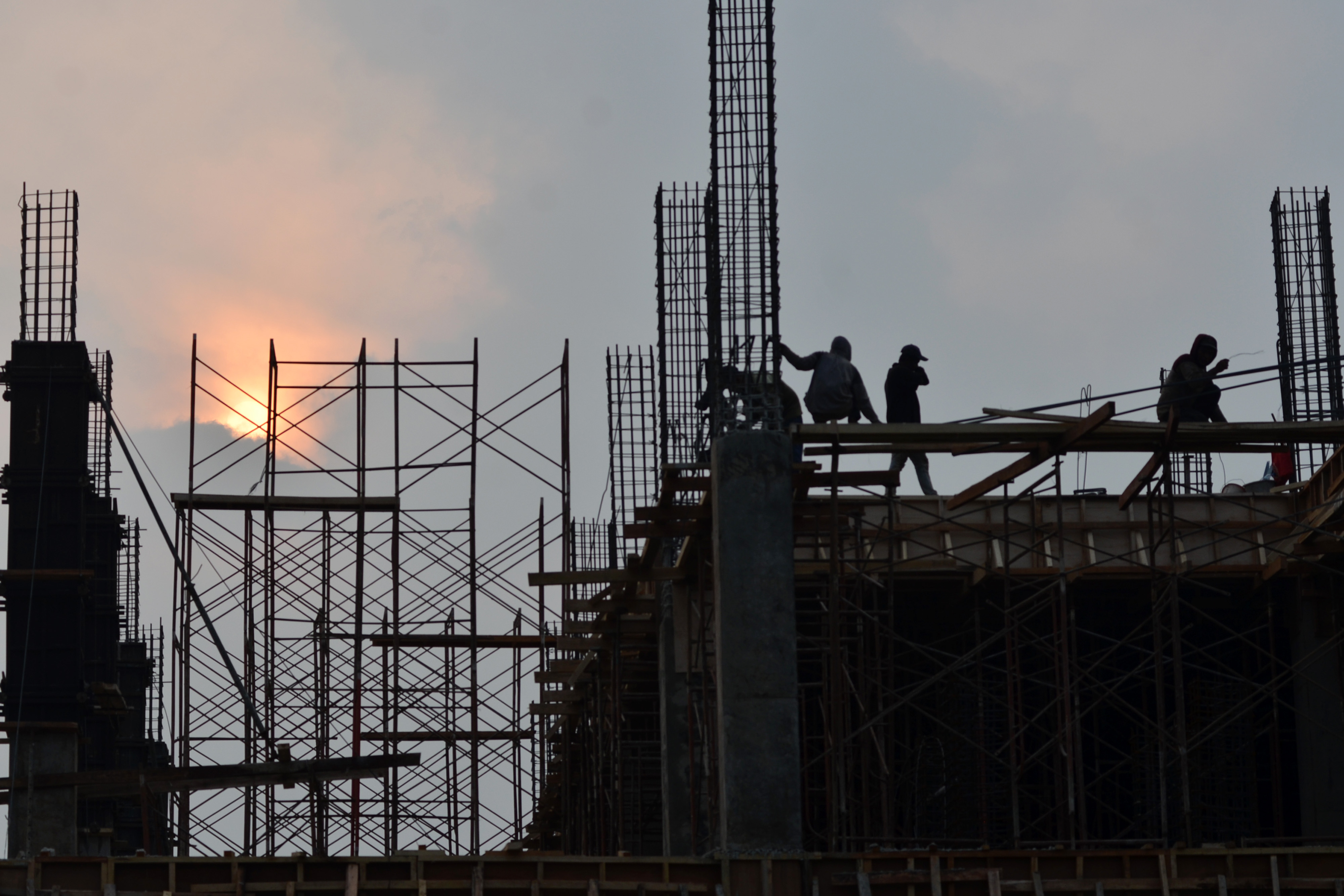 Pekerja menyelesaikan pembangunan gedung perkantoran di wilayah Bekasi.