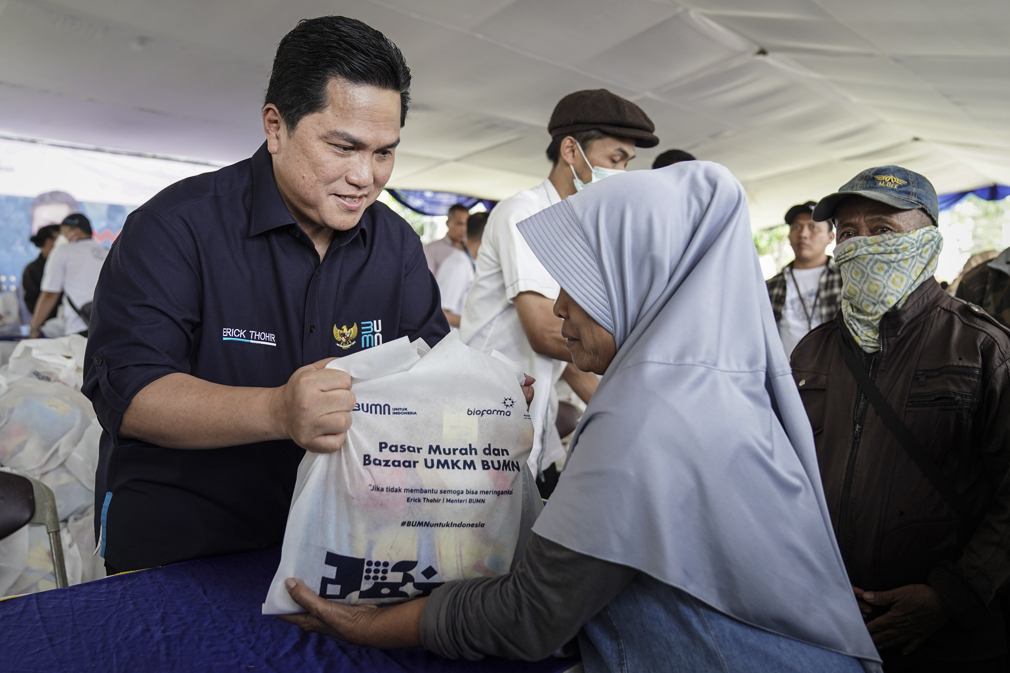 Menteri BUMN Erick Thohir (kiri) melayani warga di Pasar Murah Dan Bazaar UMKM BUMN di Purwakarta, Jawa Barat, Jumat (23/9).