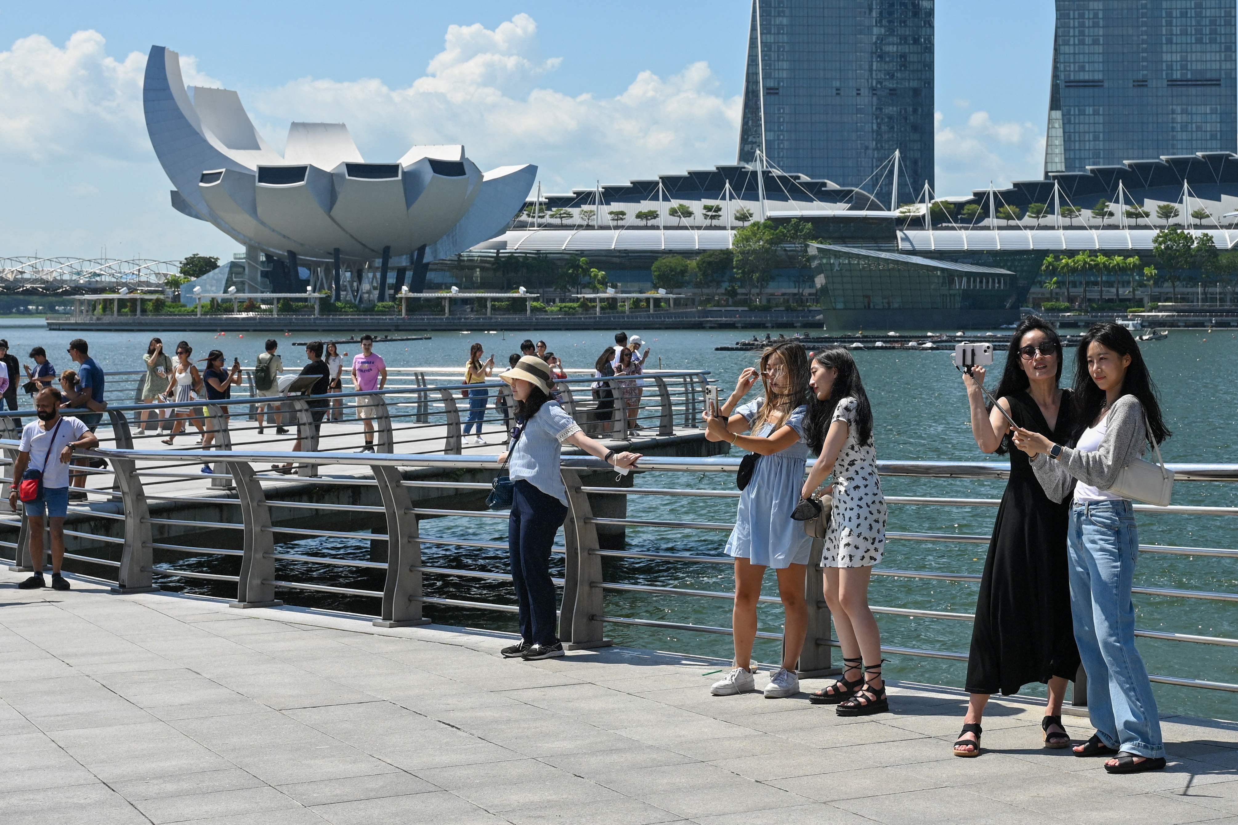 Ilustrasi. Pengunjung berfoto di depan gedung hotel dan resort Marina Bay Sands di Singapura.