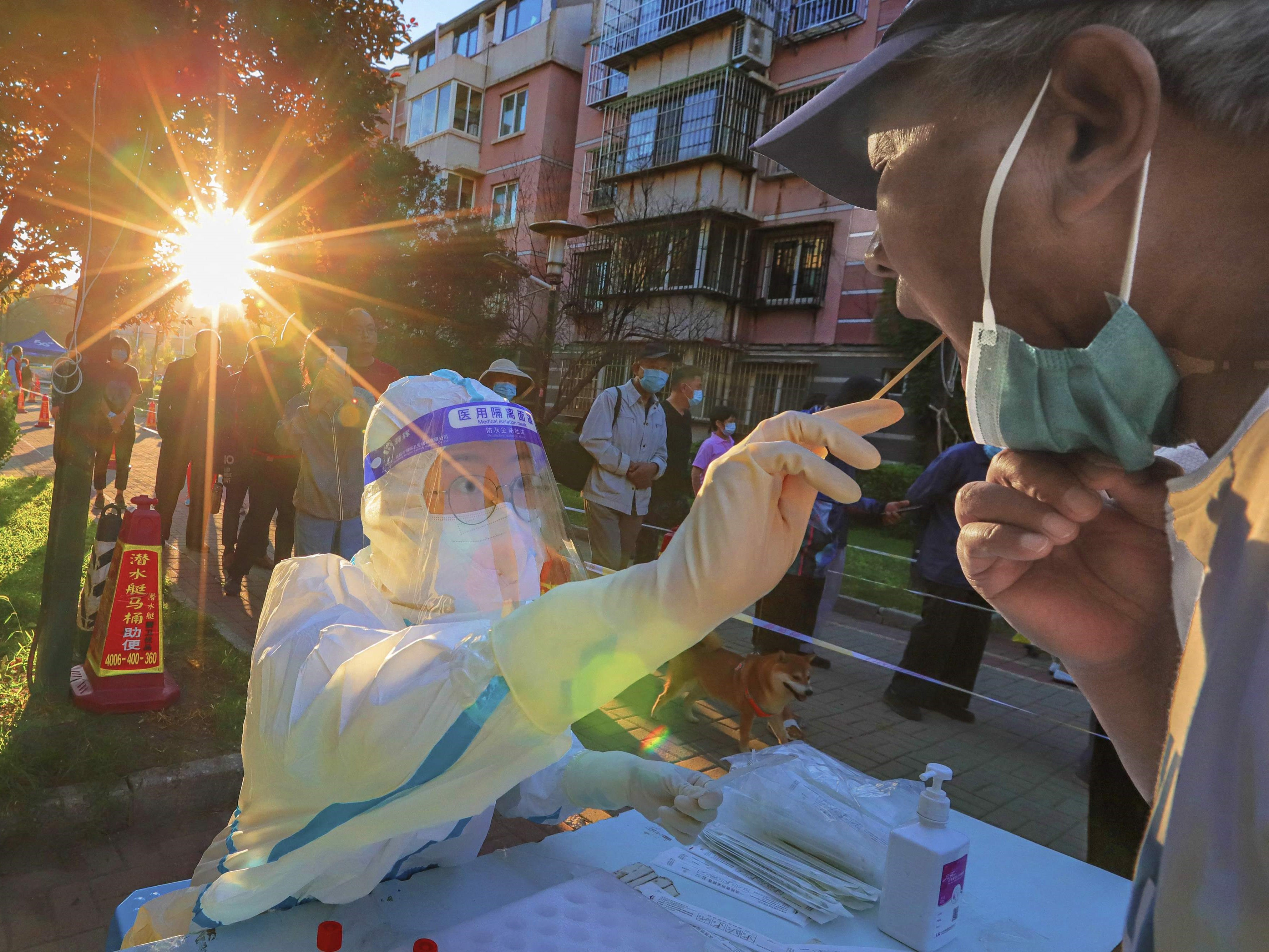 Petugas kesehatan mengambil sampel swab dari seorang pria untuk diuji covid-19 di Tianjin, utara Tiongkok. 