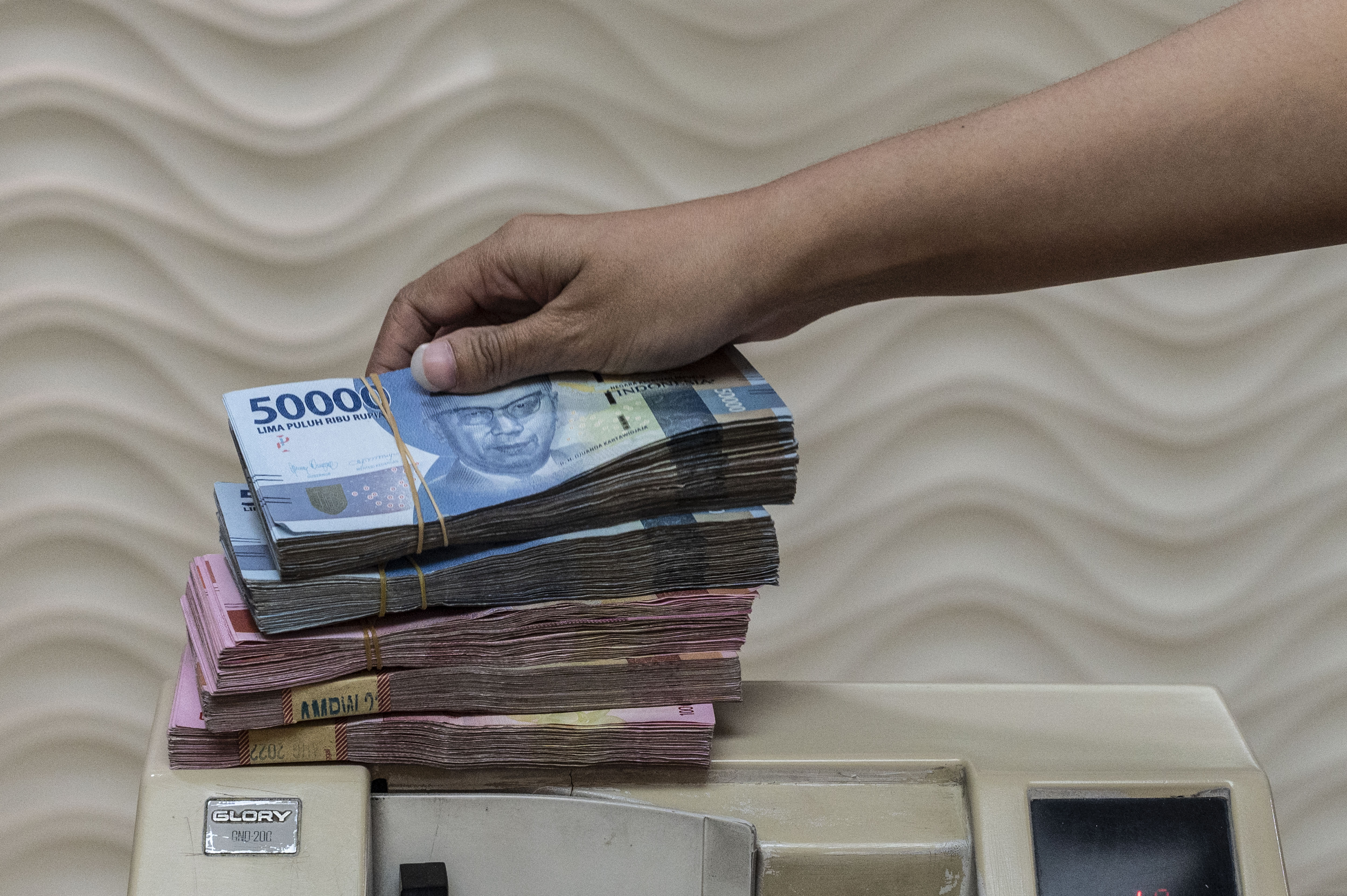  Pegawai menghitung uang Rupiah di salah satu tempat penukaran uang di Jakarta.