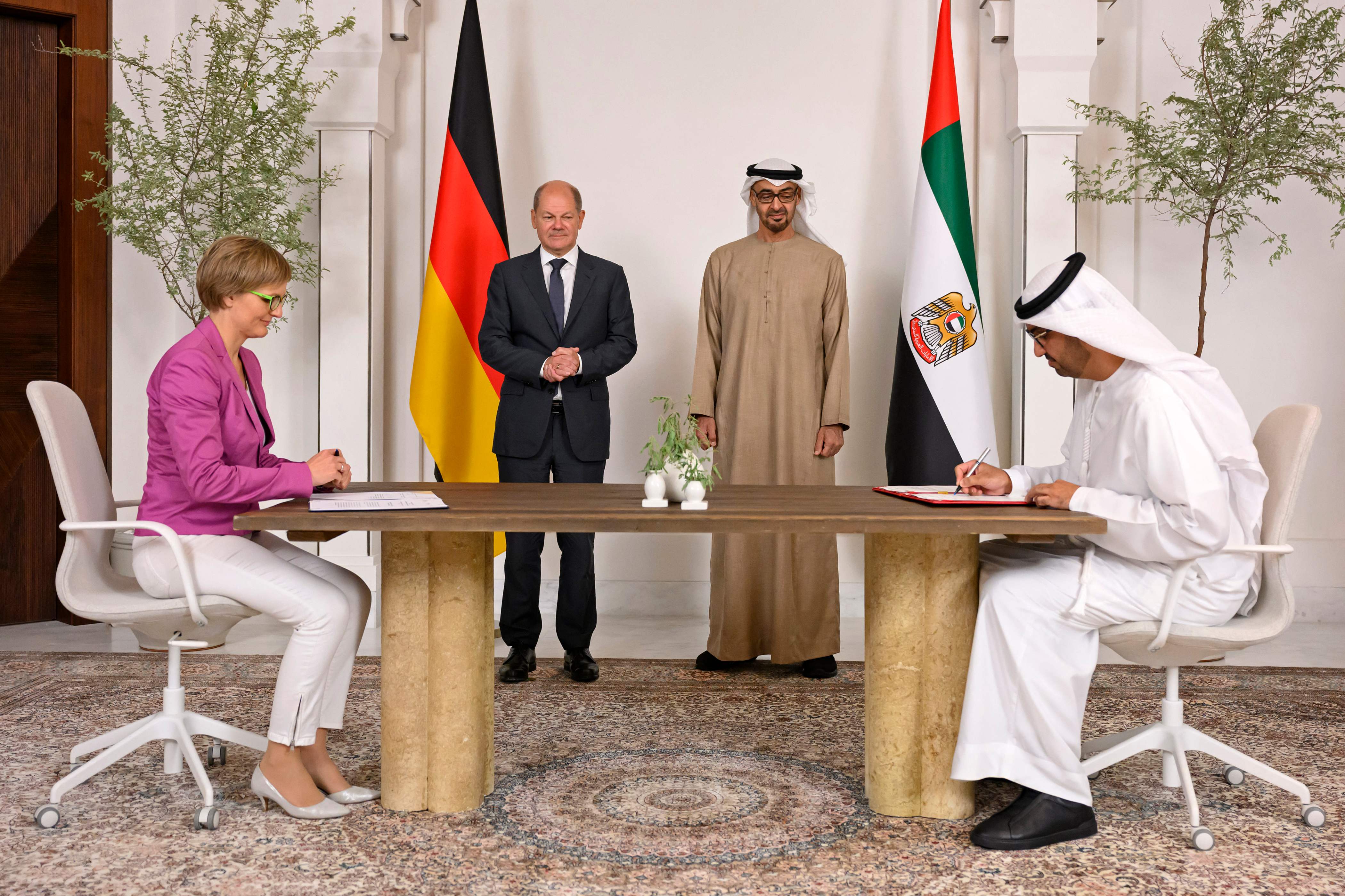 Kanselir Jerman Olaf Scholz dan Presiden UEA Sheikh Mohamed bin Zayed al-Nahyan (berdiri) menyaksikan penandatanganan kesepakatan energi. 