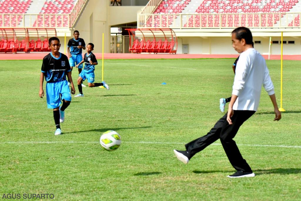 Presiden Joko Widodo menendang bola saat meluncurkan Papua Football Academy (PFA) di Stadion Lukas Enembe, Kabupaten Jayapura, Papua.