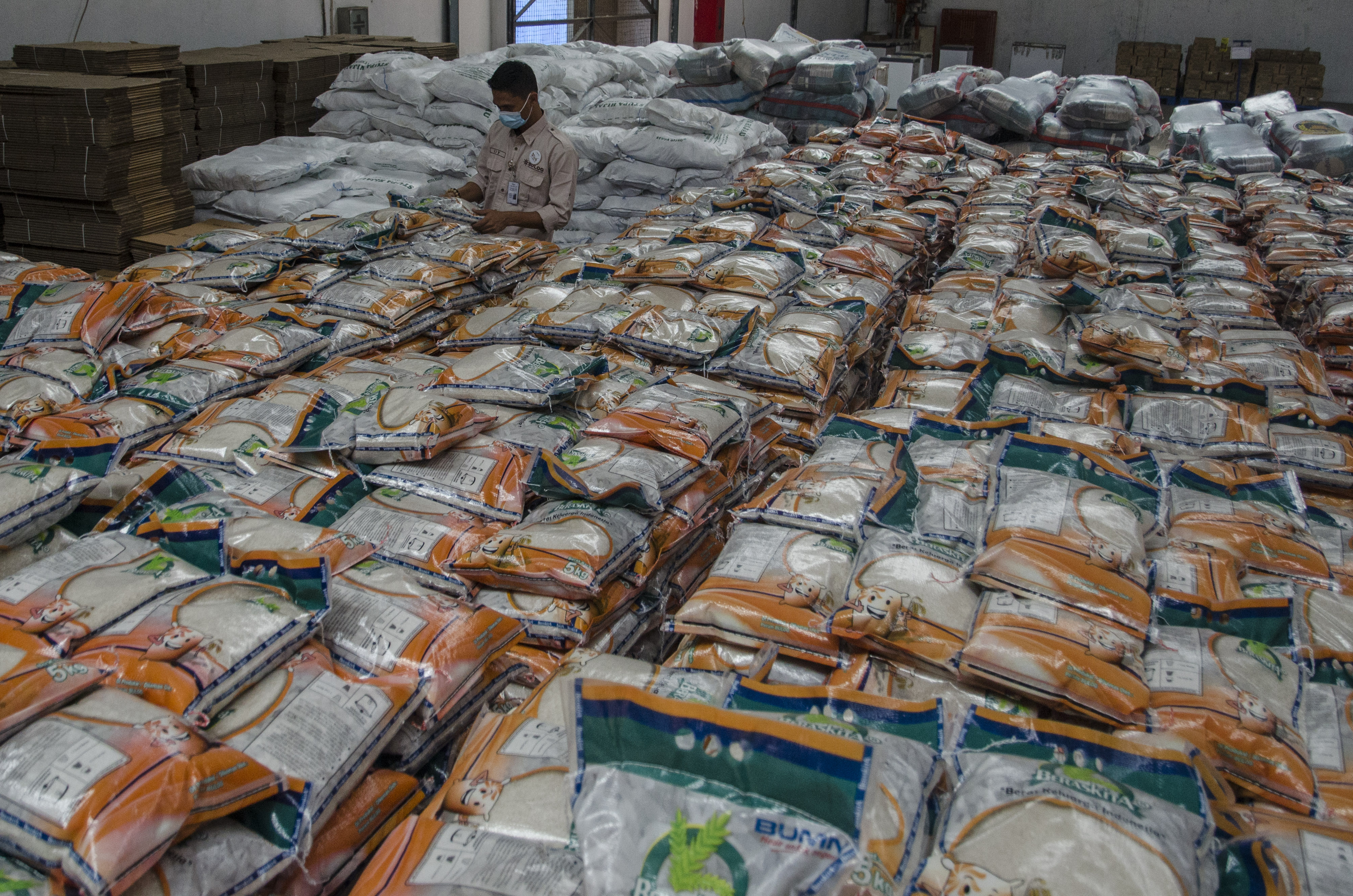 Petugas memeriksa stok kebutuhan pangan pokok di Komplek Pergudangan Bulog, Bandung, Jawa Barat