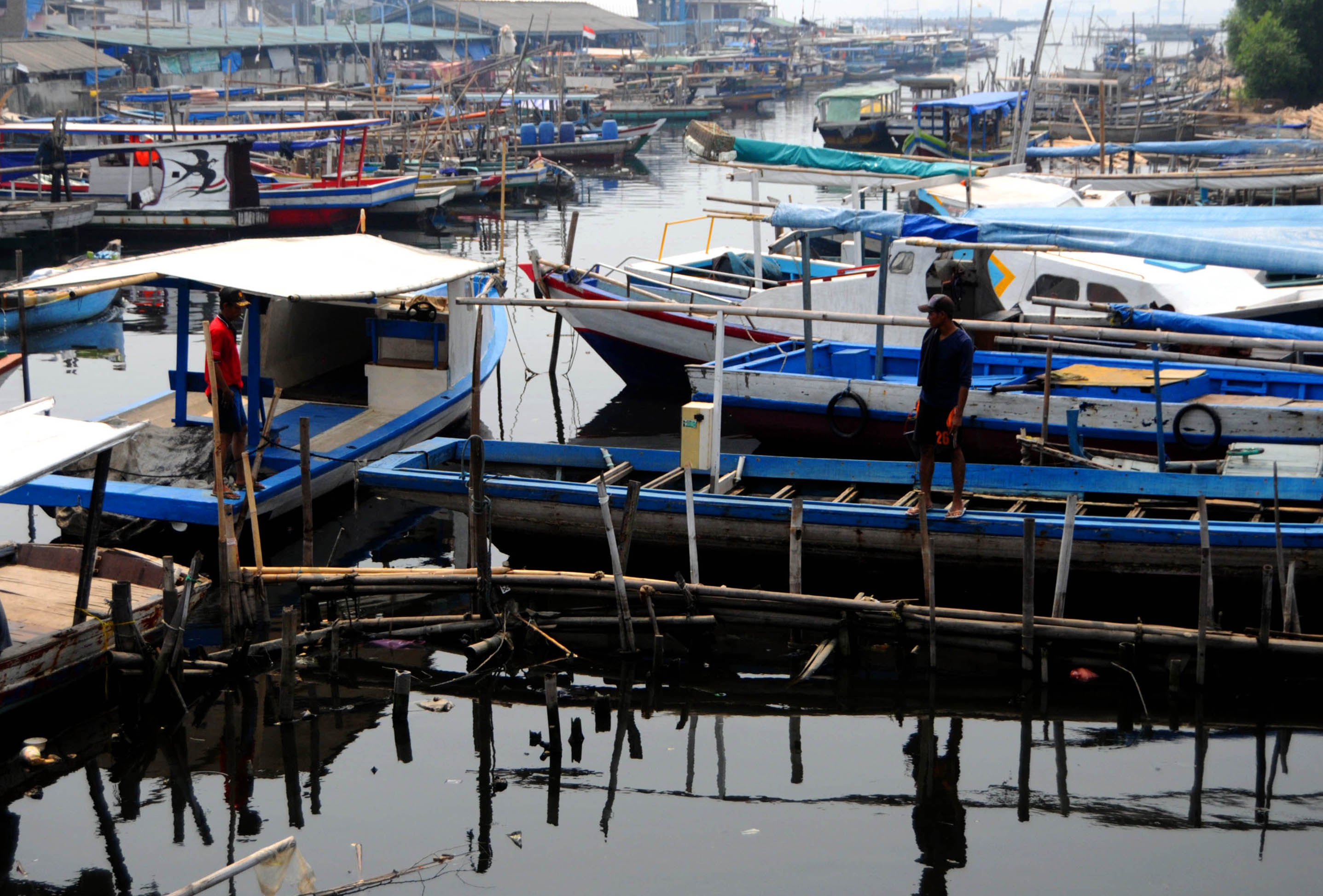 Sejumlah nelayan beraktivitas di atas kapal mereka di Dermaga Kamal Muara, Jakarta Utara.