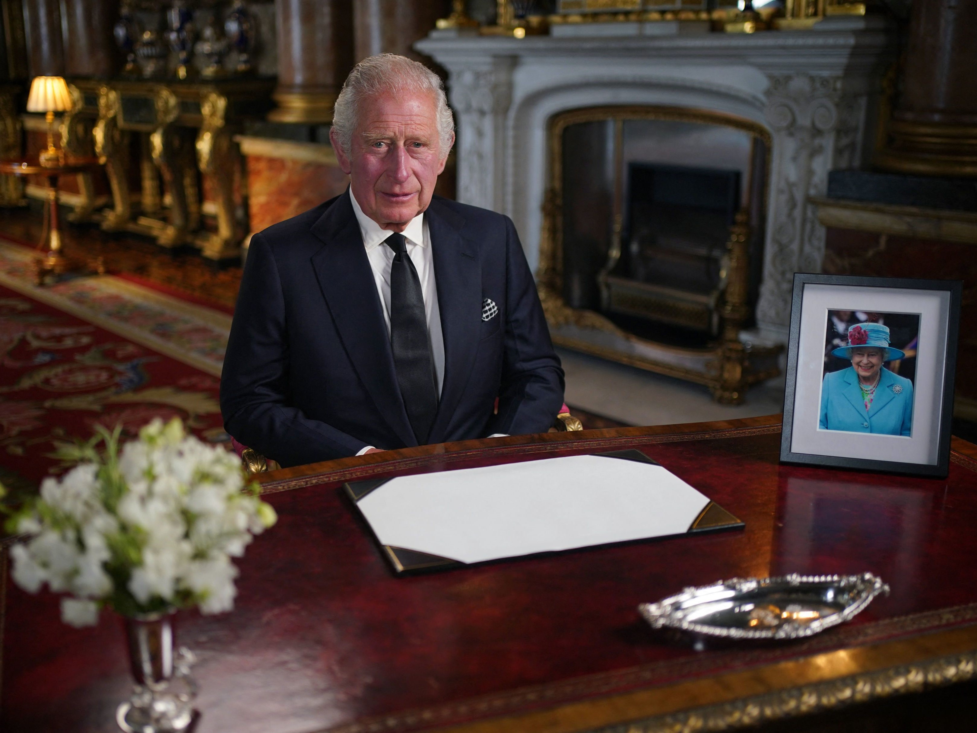 Raja Inggris Charles III berpidato yang disiarkan televisi kepada Bangsa dan Persemakmuran dari Ruang Gambar Biru di Istana Buckingham. 
