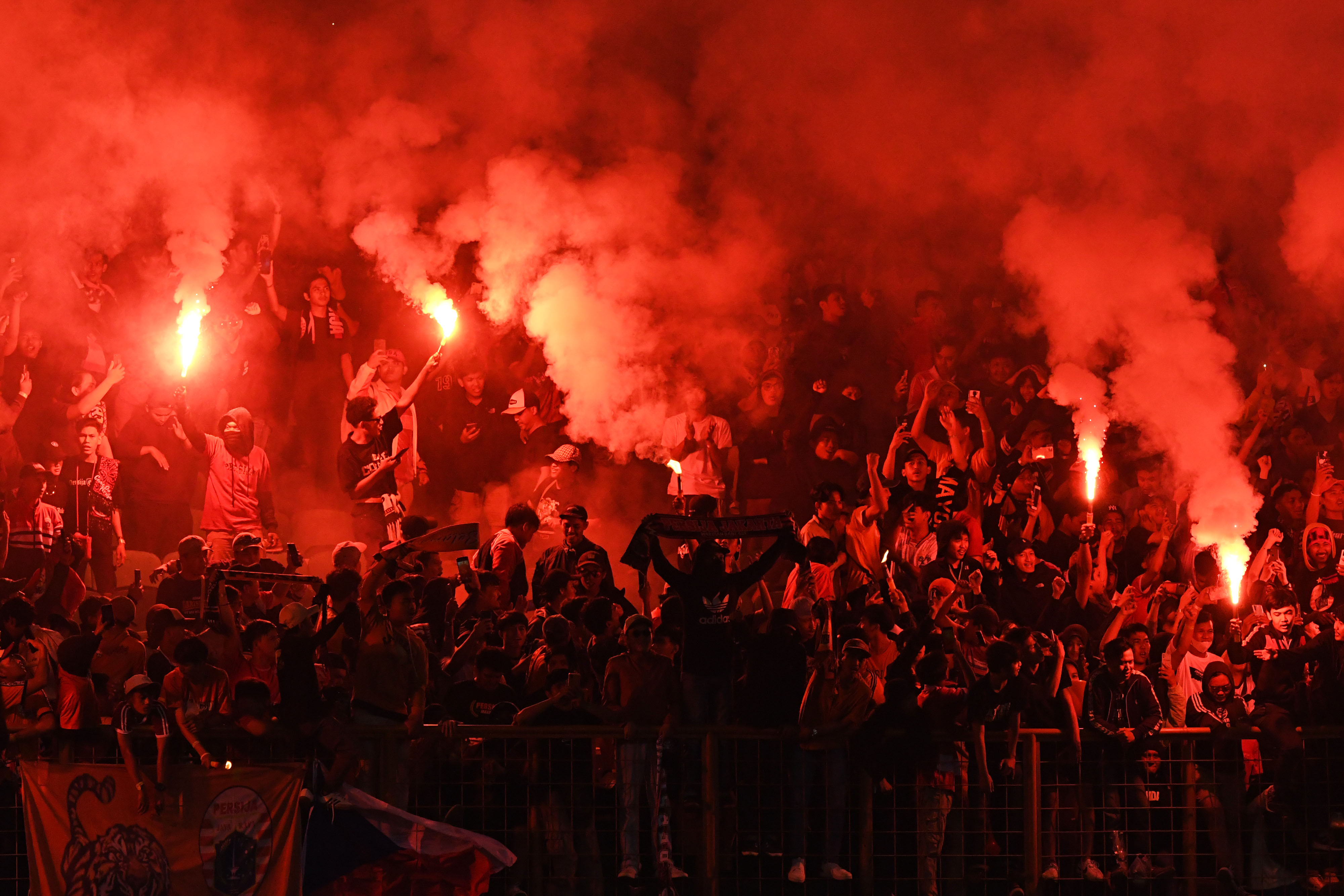 Jakmania menyalakan suar saat mendukung Persija Jakarta dalam laga uji coba lawan Rans Nusantara FC di Cikarang, Sabtu (16/7).
