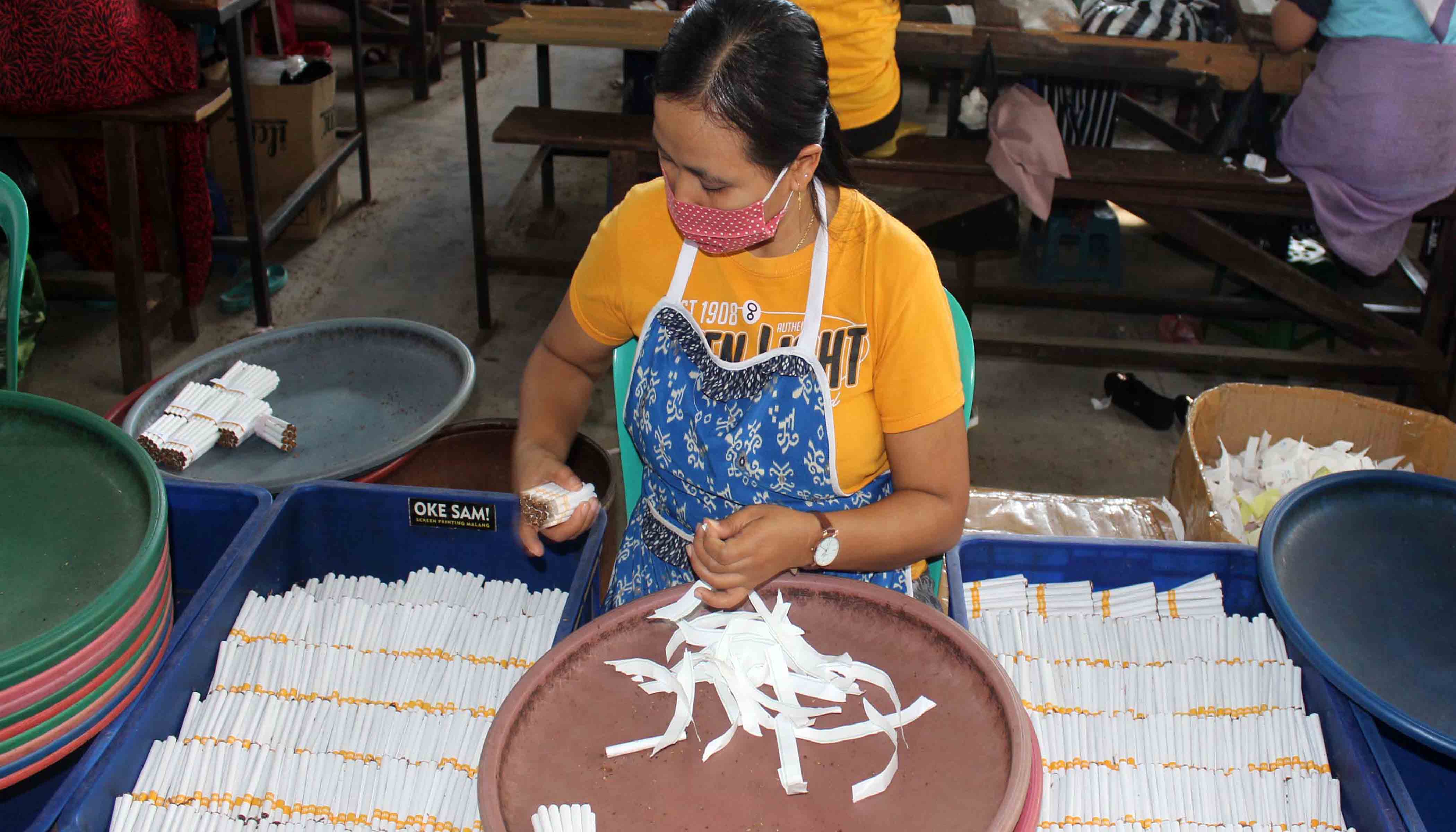 Pekerja perusahaan rokok di Jawa Timur tengah mengemas hasil produksi