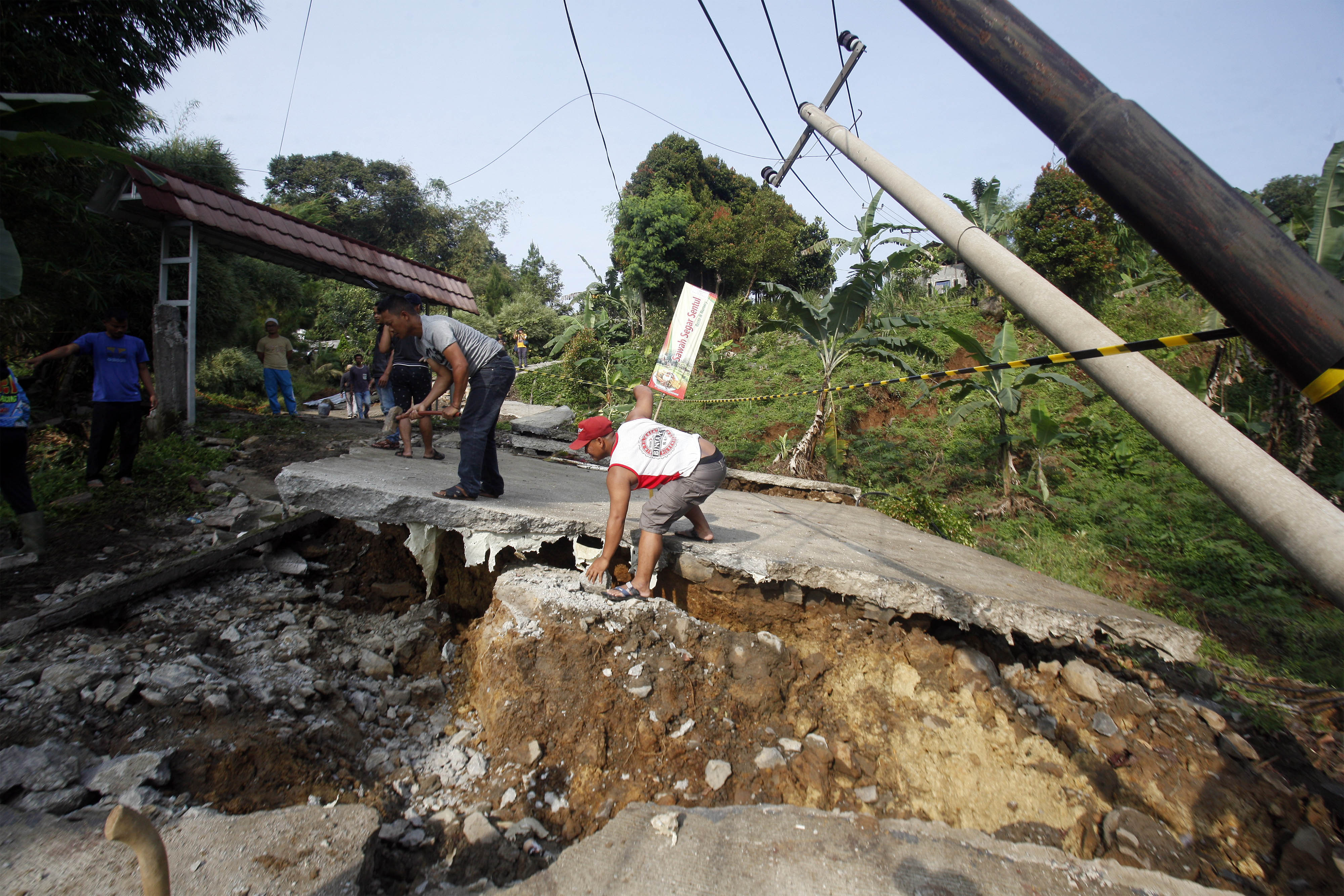 Kondisi jalan yang rusak akibat pergerakan tanah di Bojong Koneng, Babakan Madang, Kabupaten Bogor, Jawa Barat, Jumat (16/9).