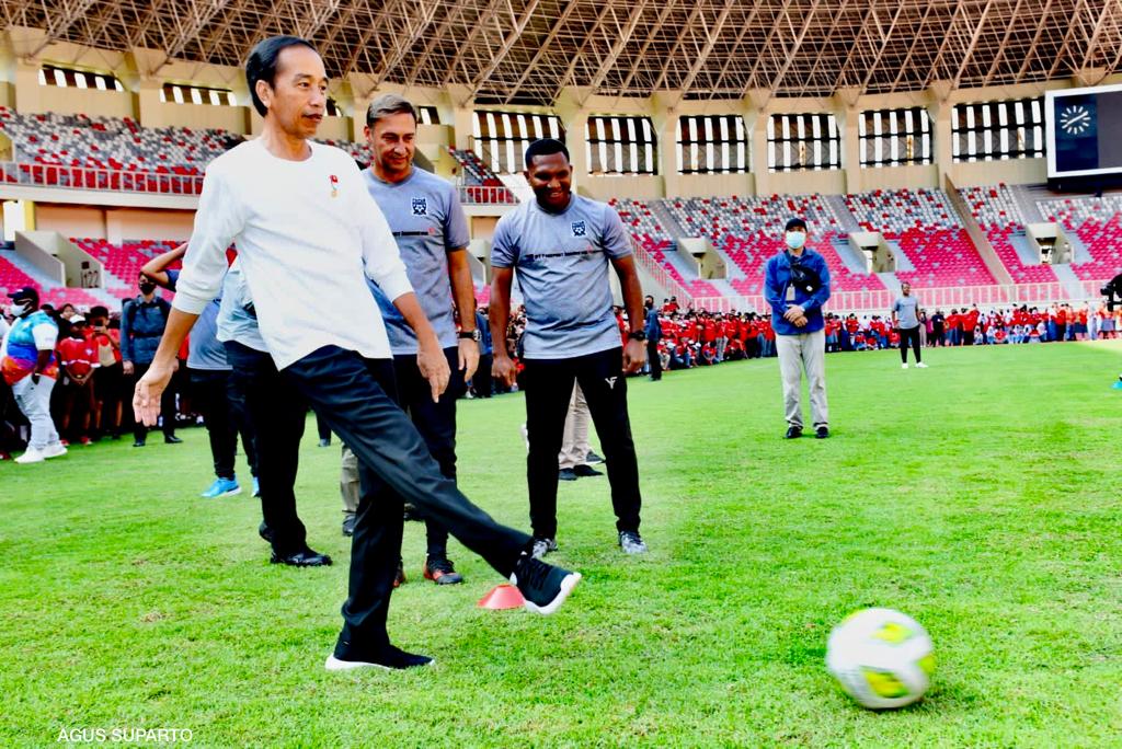 Presiden Jokowi menendang bola saat meluncurkan Papua Football Academy (PFA).