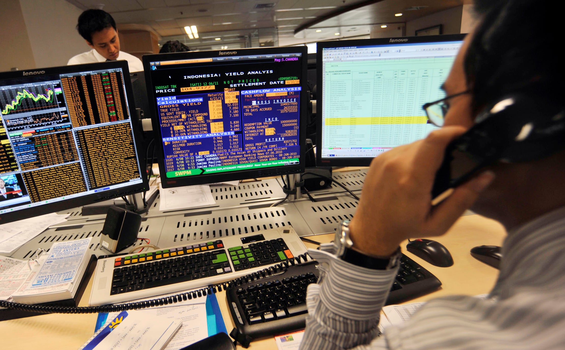 Pegawai bank mengamati harga Surat Utang Negara (SUN) di BNI Treasury, Jakarta, Selasa (8/6).