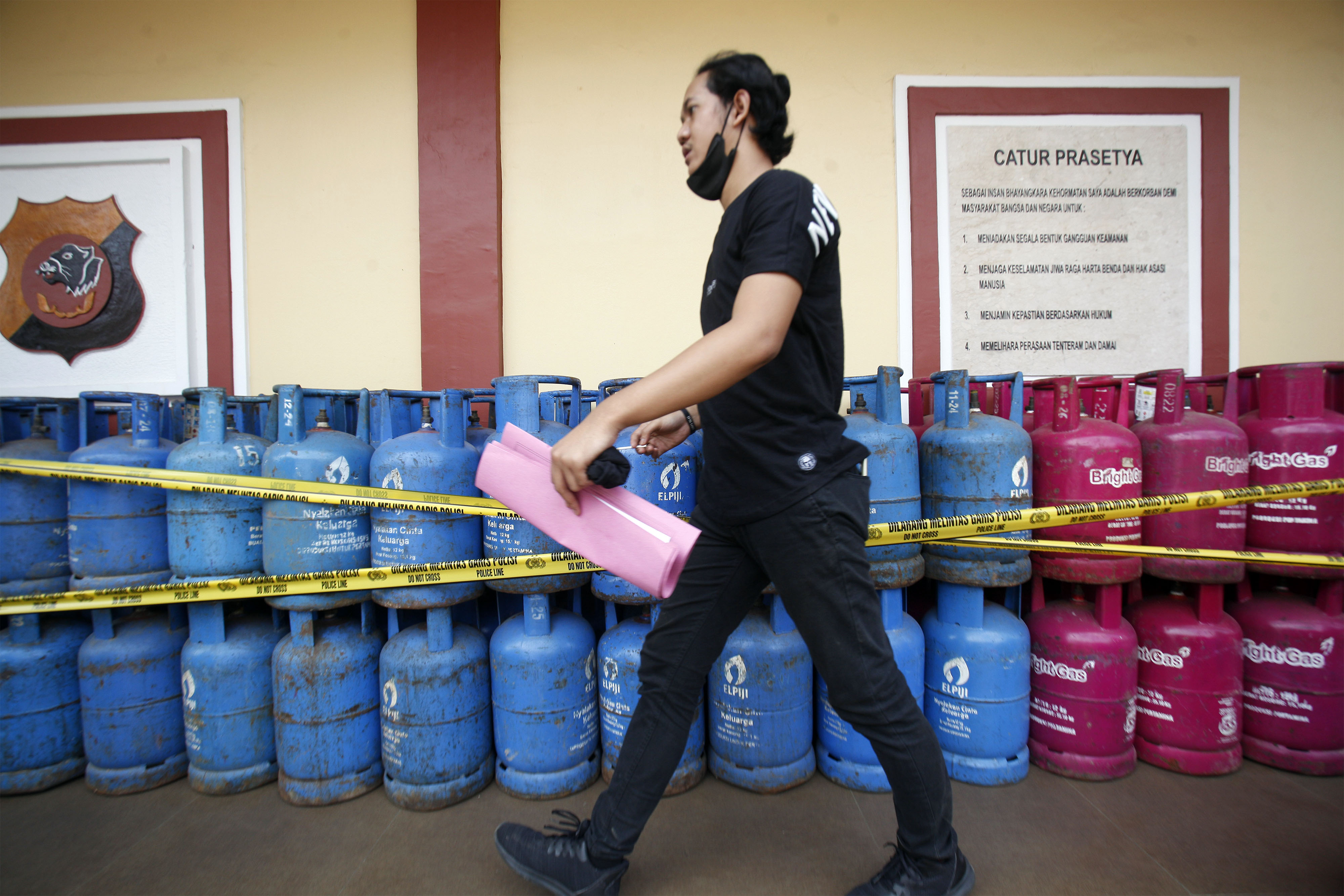 Seorang penyidik Satreskrim Polres Bogor berjalan di depan barang bukti saat pengungkapan kasus di Mapolres Bogor, Jawa Barat, Selasa (6/9).