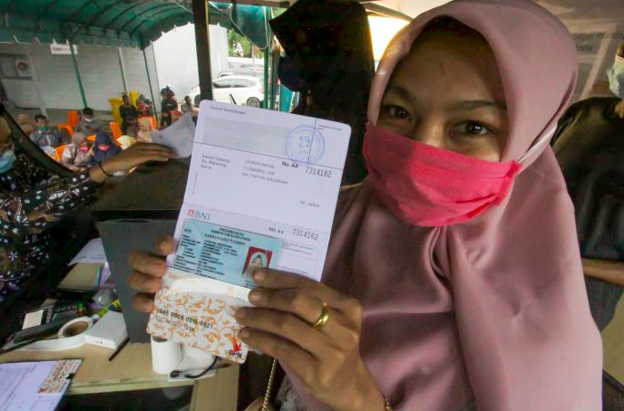 Guru honorer menunjukkan dokumen buku tabungan bank saat pencairan BSU di Lhokseumawe, Aceh.  