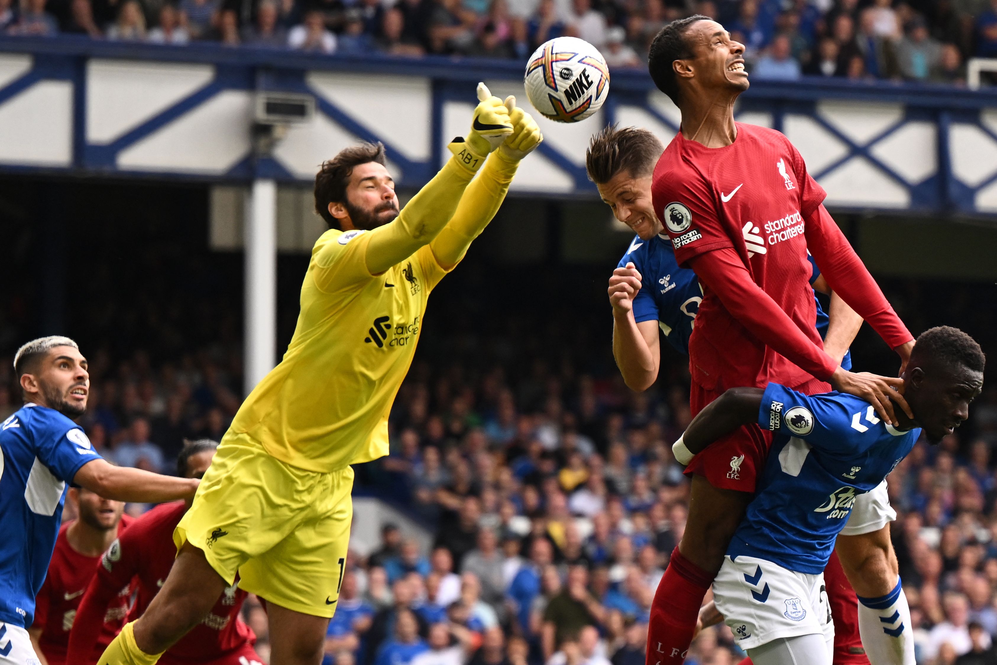 Kiper Liverpool Alisson Becker menghalau bola dari ancaman serangan para pemain Everton dalam lanjutan Liga Primer Inggris, Sabtu (3/9).