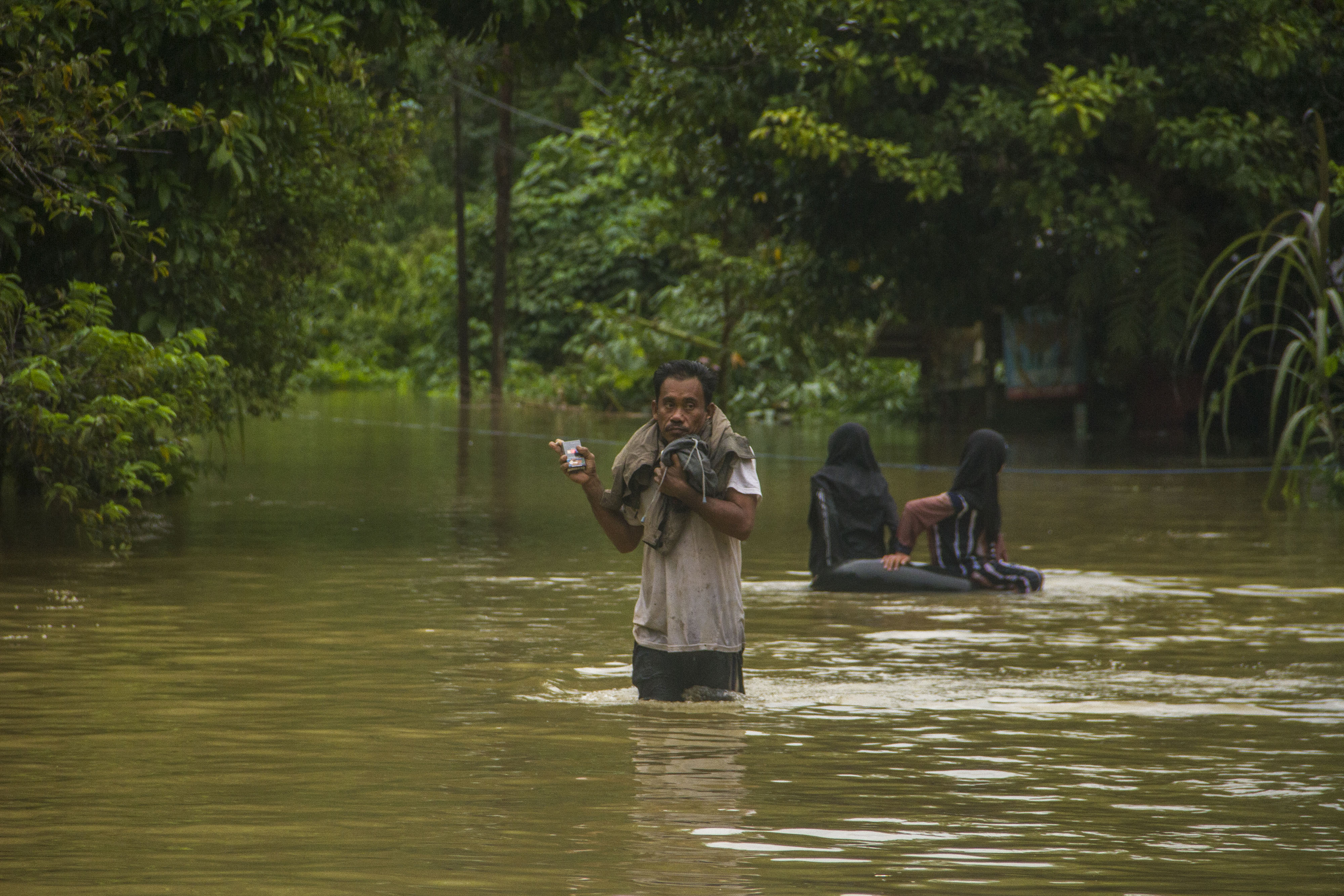 Warga melintasi genangan banjir di Desa Haliau, Kabupaten Hulu Sungai Tengah, Kalimantan Selatan, Jumat (9/9).