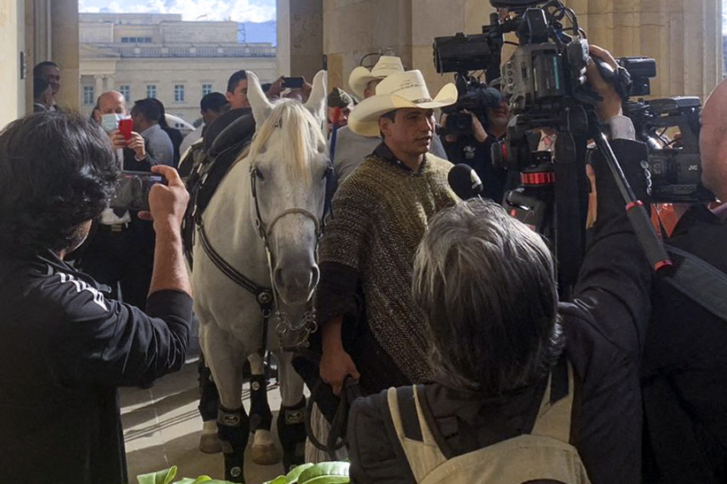 Anggota Kongres Kolombia Alirio Barrera berbicara kepada wartawan sembari membawa kuda miliknya di gedung Kongres.