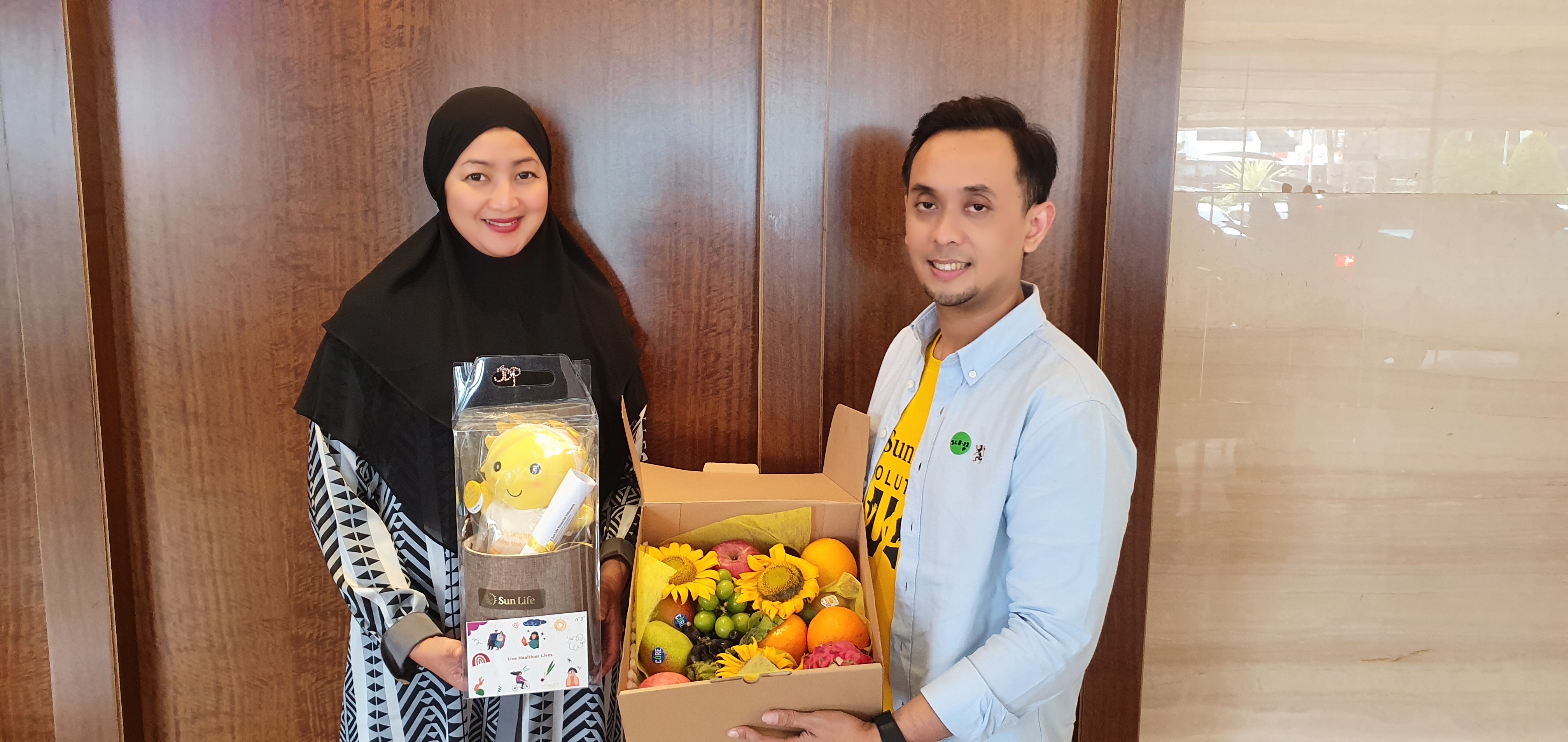 dr. Aditya Indra Kusuma, Head of Claim Sun Life Indonesia (kanan) memberikan bingkisan Touch of Care kepada keluarga Nasabah