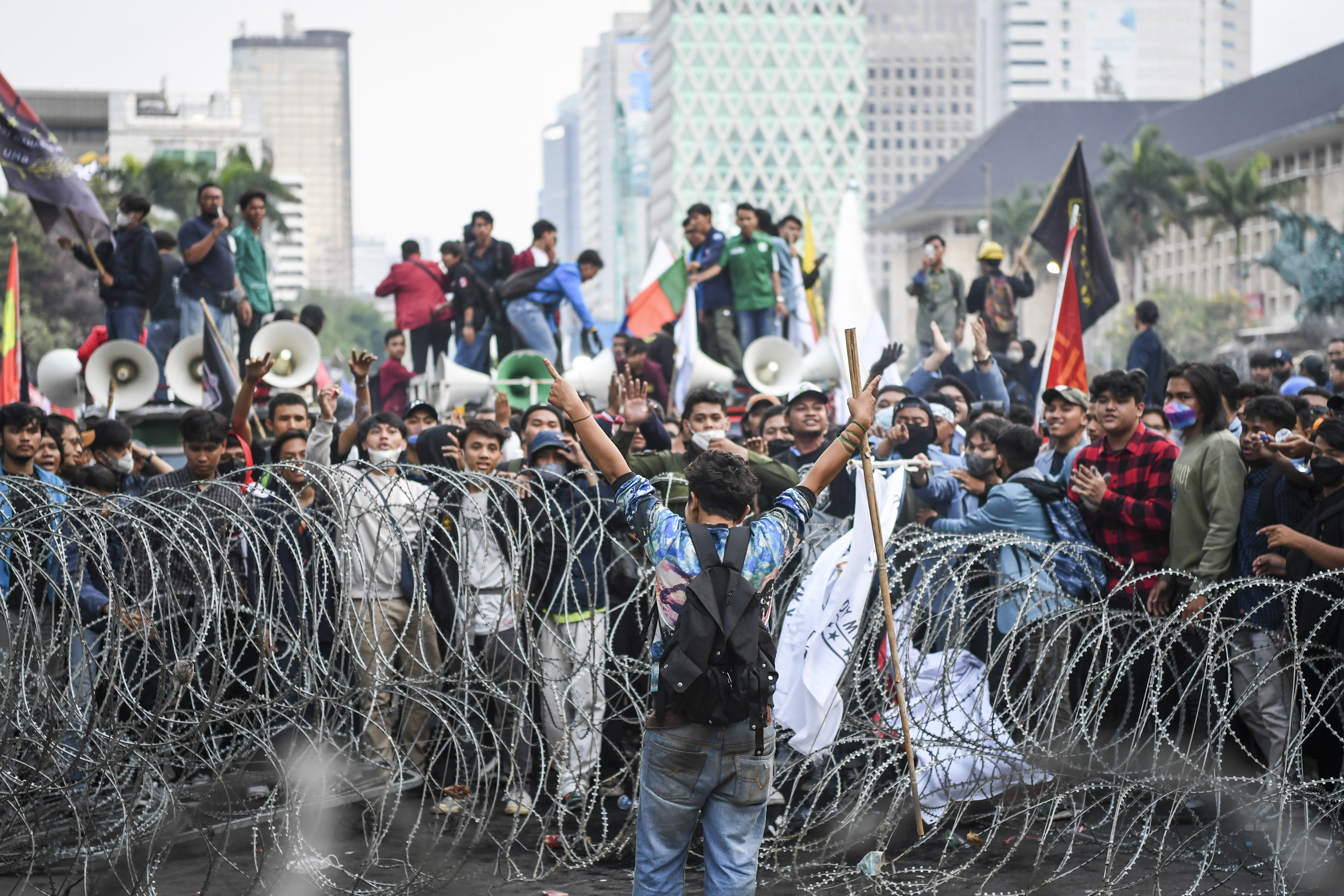 Sejumlah pengunjuk rasa menarik pagar kawat berduri dalam aksi protes di Jakarta.