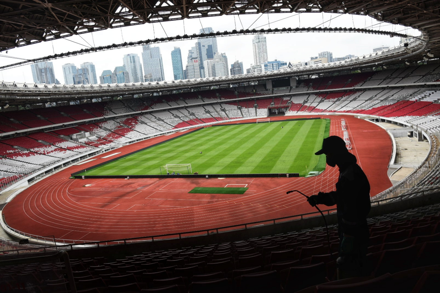 Petugas menyemprotkan cairan disinfektan ke area Stadion Utama Gelora Bung Karno, Jakarta.