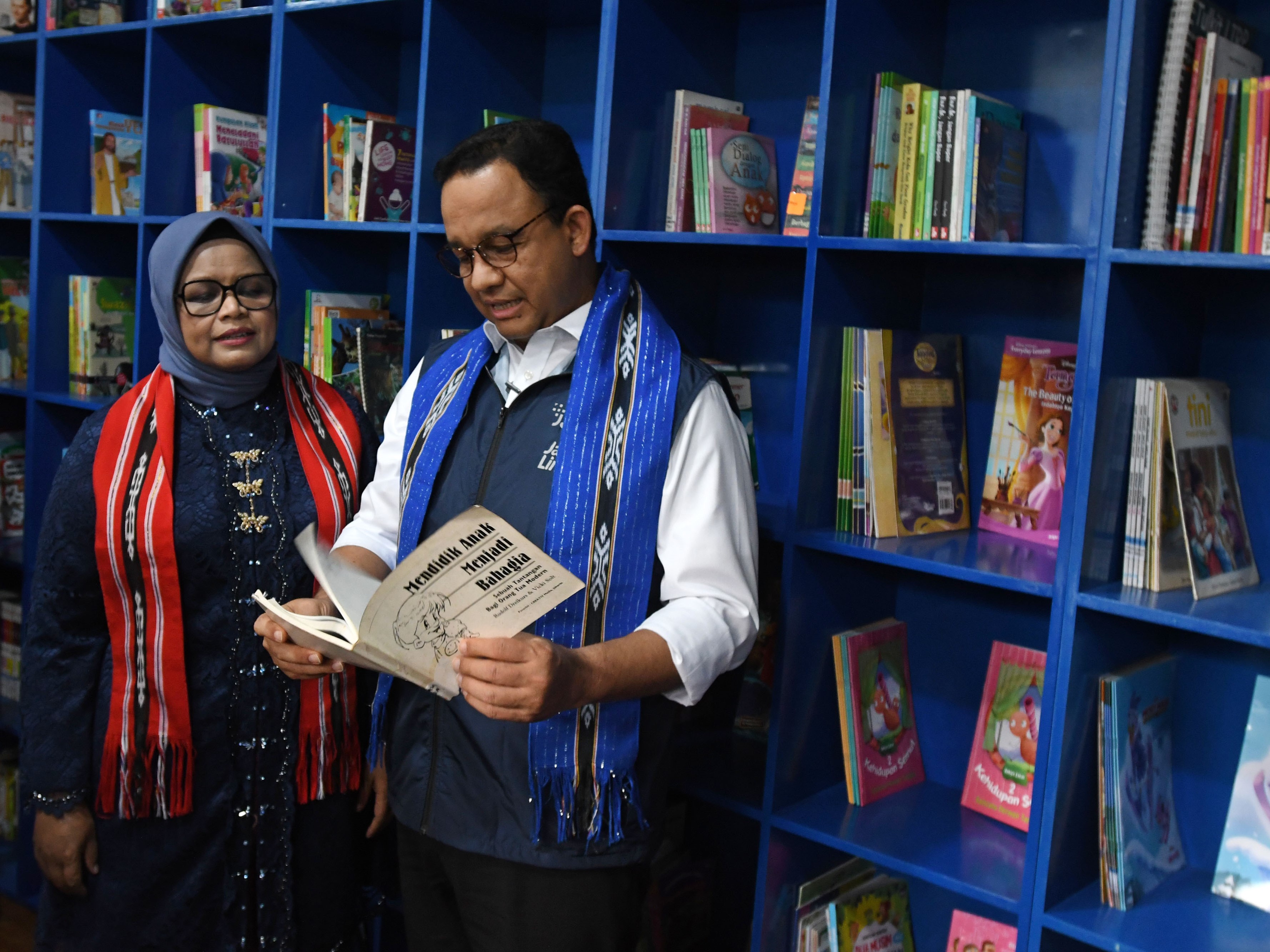 Gubernur DKI Jakarta Anies Baswedan (kanan) dan istri Fery Farhati membaca buku milik perpustakaan Taman Literasi Martha Christina Tiahahu.