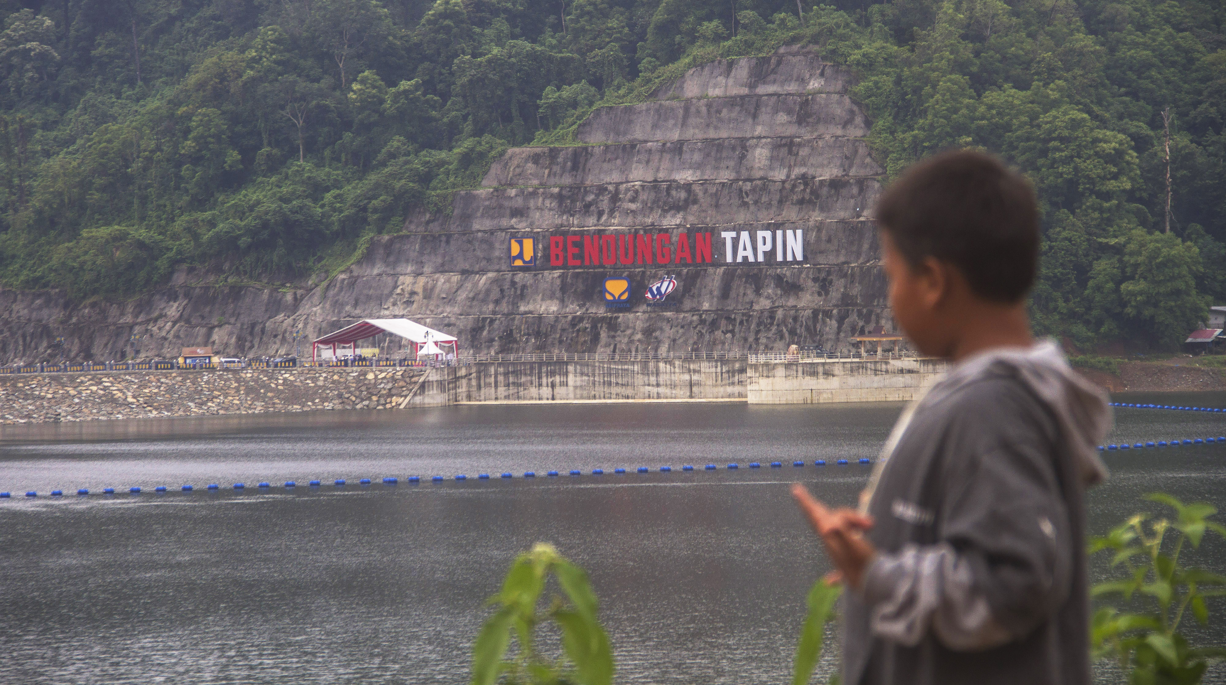 Seorang anak melintas di Bendungan Tapin di Kalimantan Selatan seusai diresmikan Presiden Jokowi awal 2021.