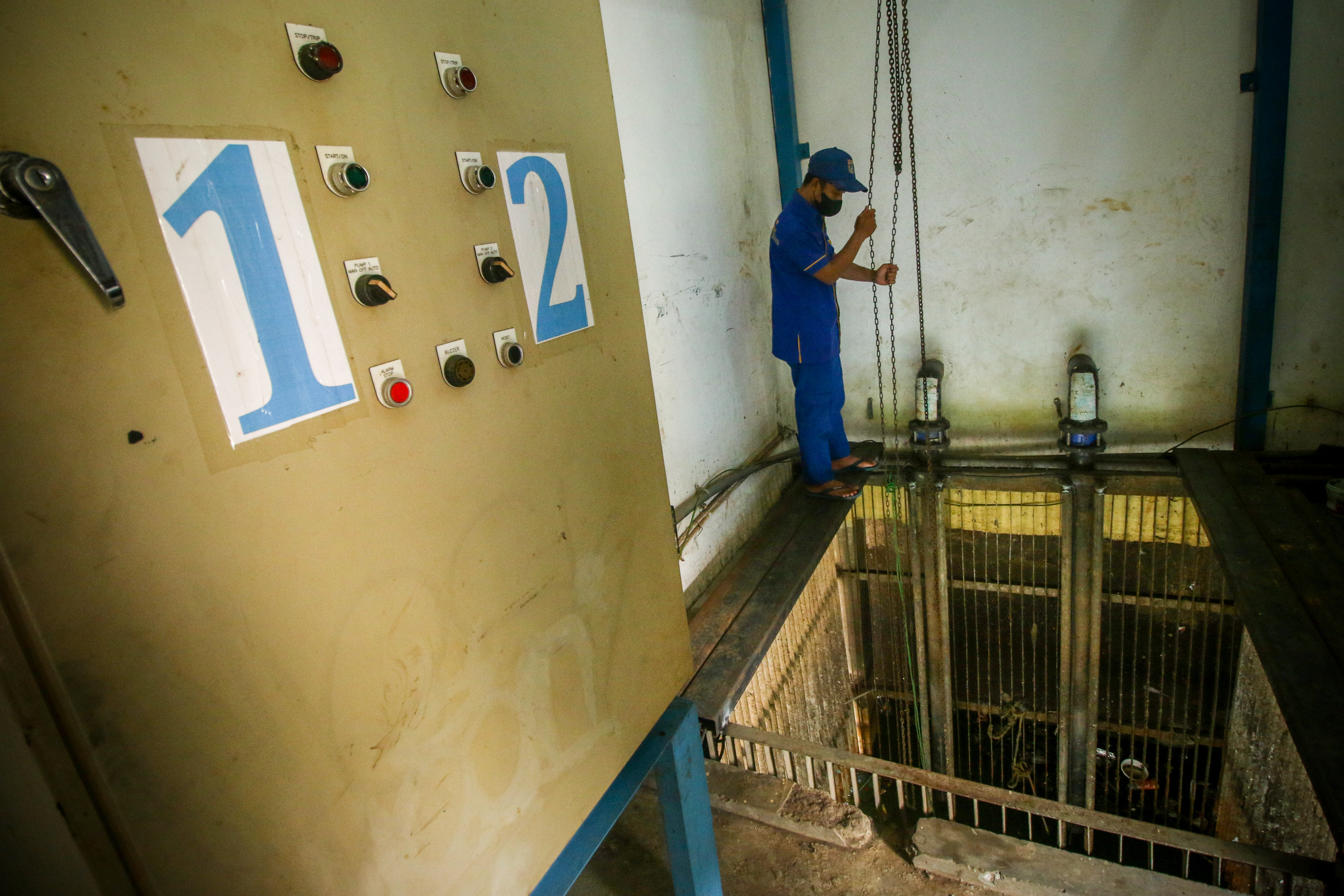 Petugas Suku Dinas Sumber Daya Air Jakarta Pusat mengecek pompa air di Rumah Pompa Jati Pinggir 3, Jakarta, Selasa (19/10). 