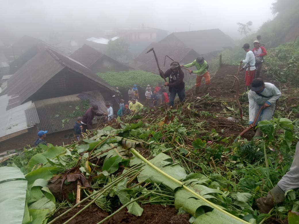 Petugas dibantu warga membersihkan material longsor yang menutup jalan antardesa di Cigalontang, Tasikmalaya, Jawa Barat, Selasa (4/10).
