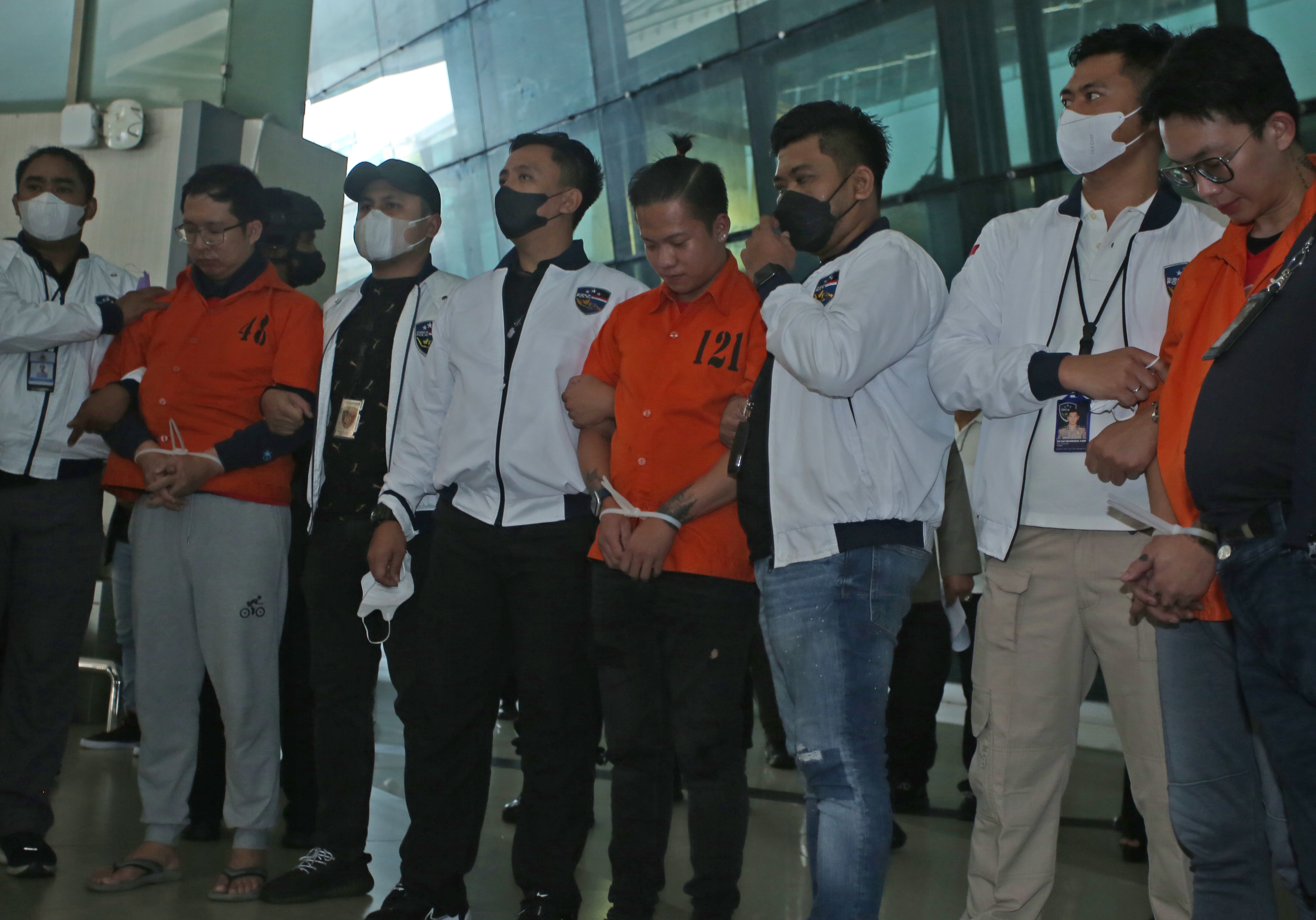 Petugas kepolisian memperlihatkan tersangka bandar besar judi online jaringan Jakarta saat setibanya dari Kamboja, Sabtu (15/10). 