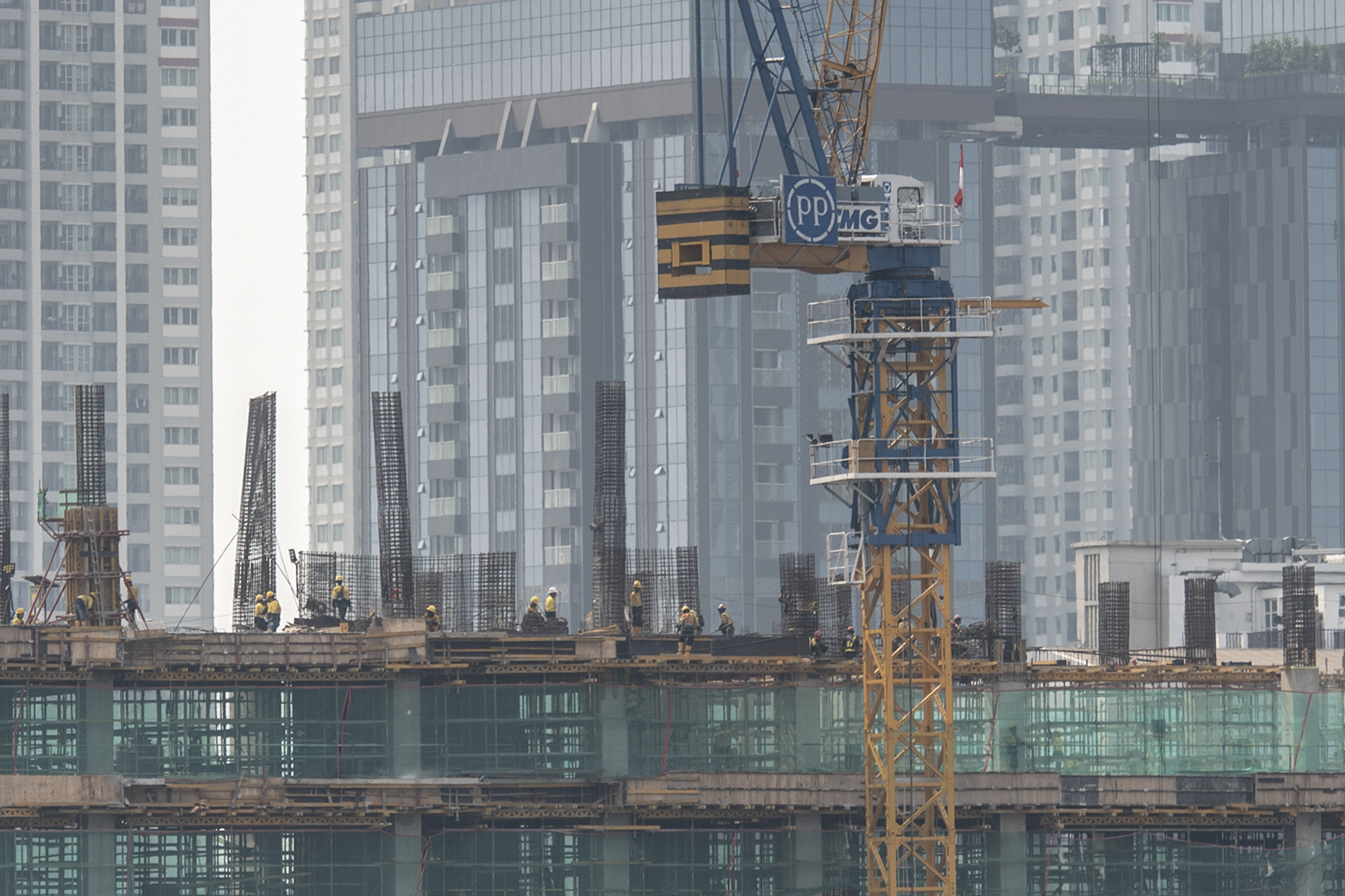 Potret pekerja menyelesaikan pembangunan gedung bertingkat di Jakarta.