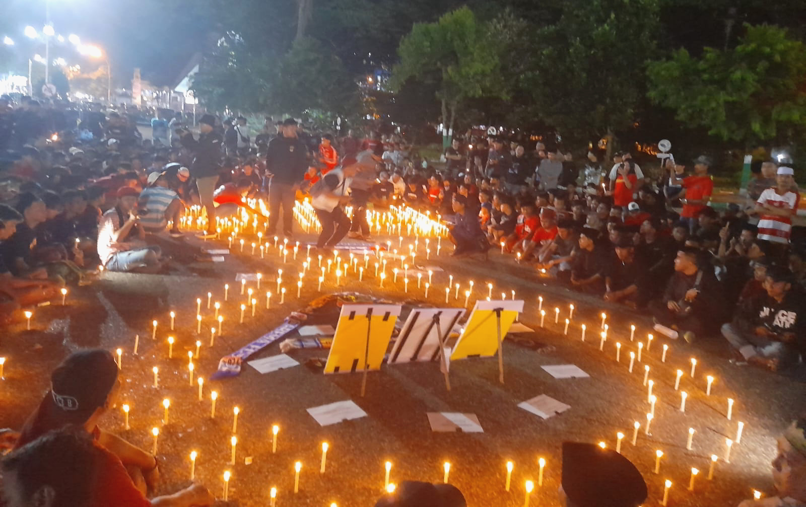 Suporter Madura United menyalakan lilin dan menggelar doa bersama untuk korban tragedi Kanjuruhan di Monumen Arek Lancor