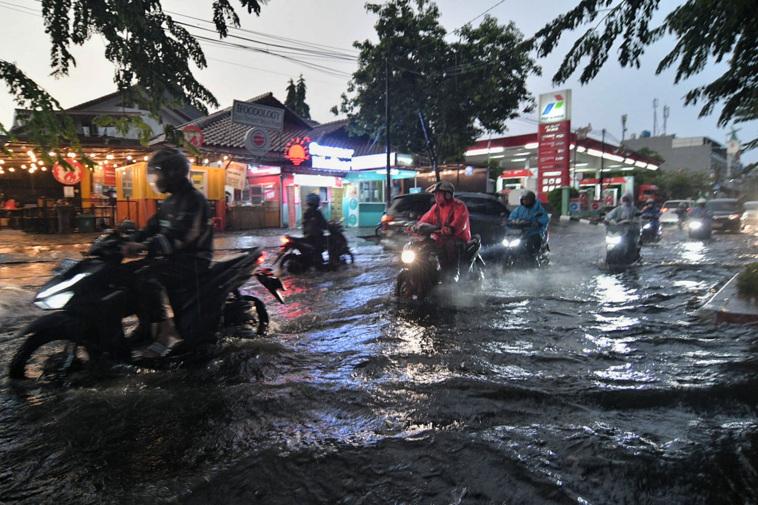 Pengendara melintasi banjir yang menggenangi wilayah Cempaka Putih, Jakarta.