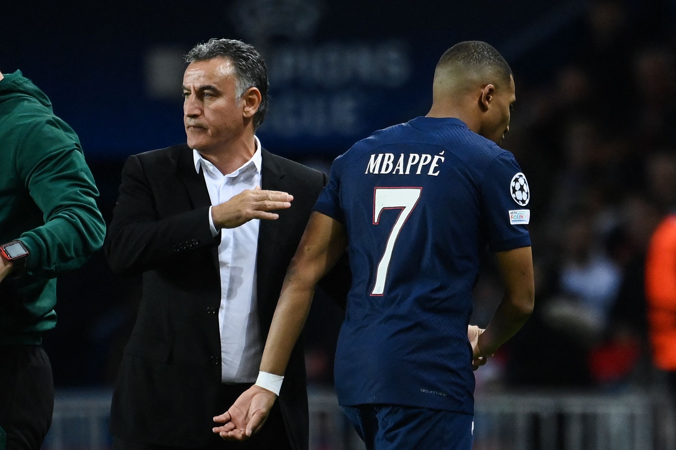Penyerang PSG Kylian Mbappe berpapasan dengan pelatih Christophe Galtier saat ditarik keluar dalam laga Liga Champions melawan Benfica.