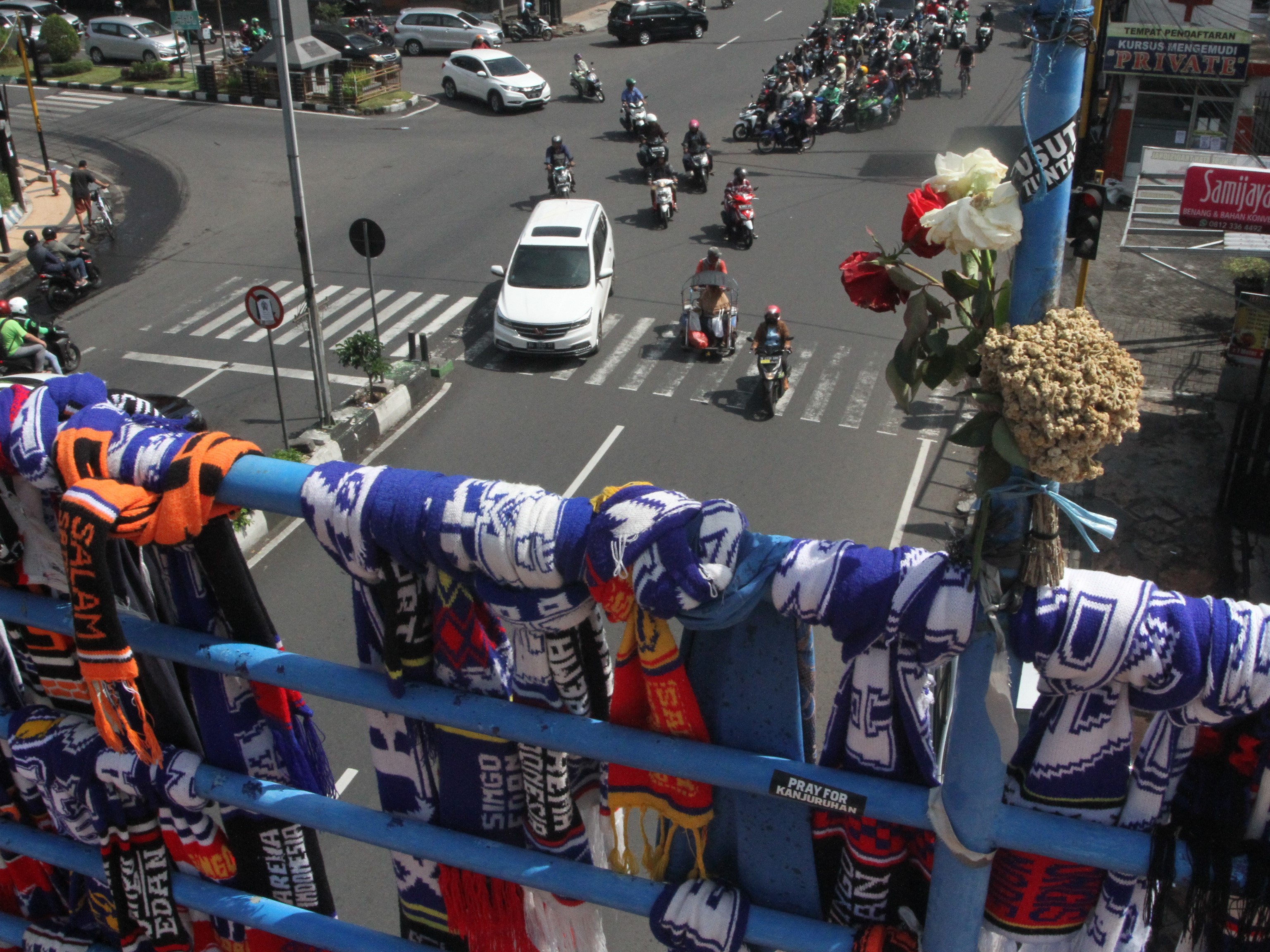 Sejumlah kendaraan melintas di bawah lokasi Aksi Gantung Syal Aremania di jembatan penyeberangan jalan Ahmad Yani, Malang, Jawa Timur, Jumat