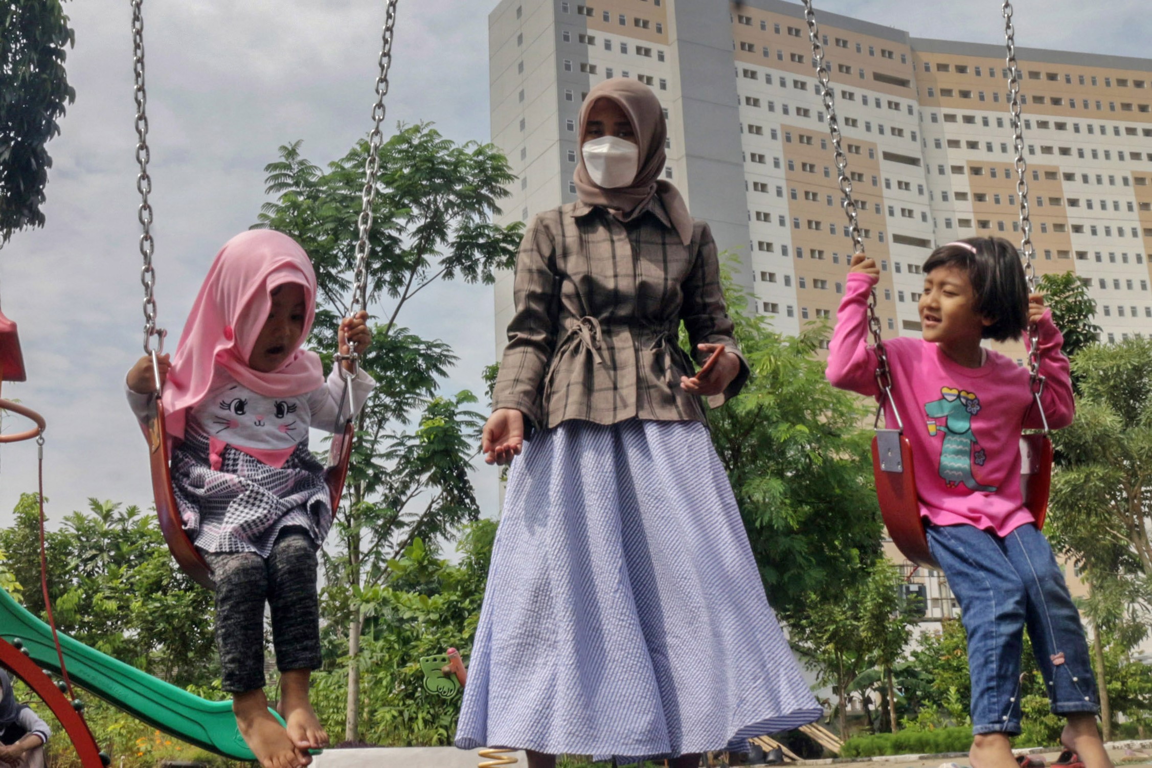 Orangtua mendampingi anaknya bermain di RPTRA Garuda, Cipayung, Jakarta Timur, Minggu (9/10/2022). 