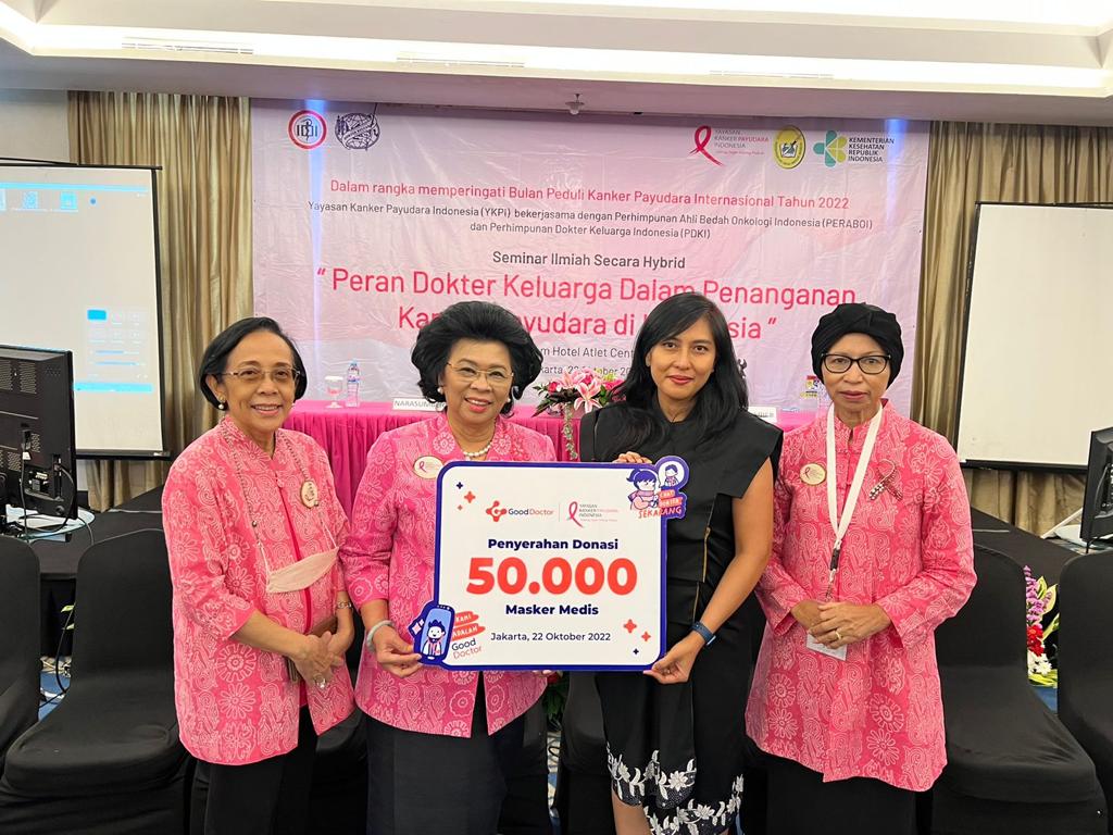 Pengurus Kanker Payudara Indonesia menunjukkan tulisan 'Penyerahan Donasi 50.000 Masker Medis' di Jakarta.