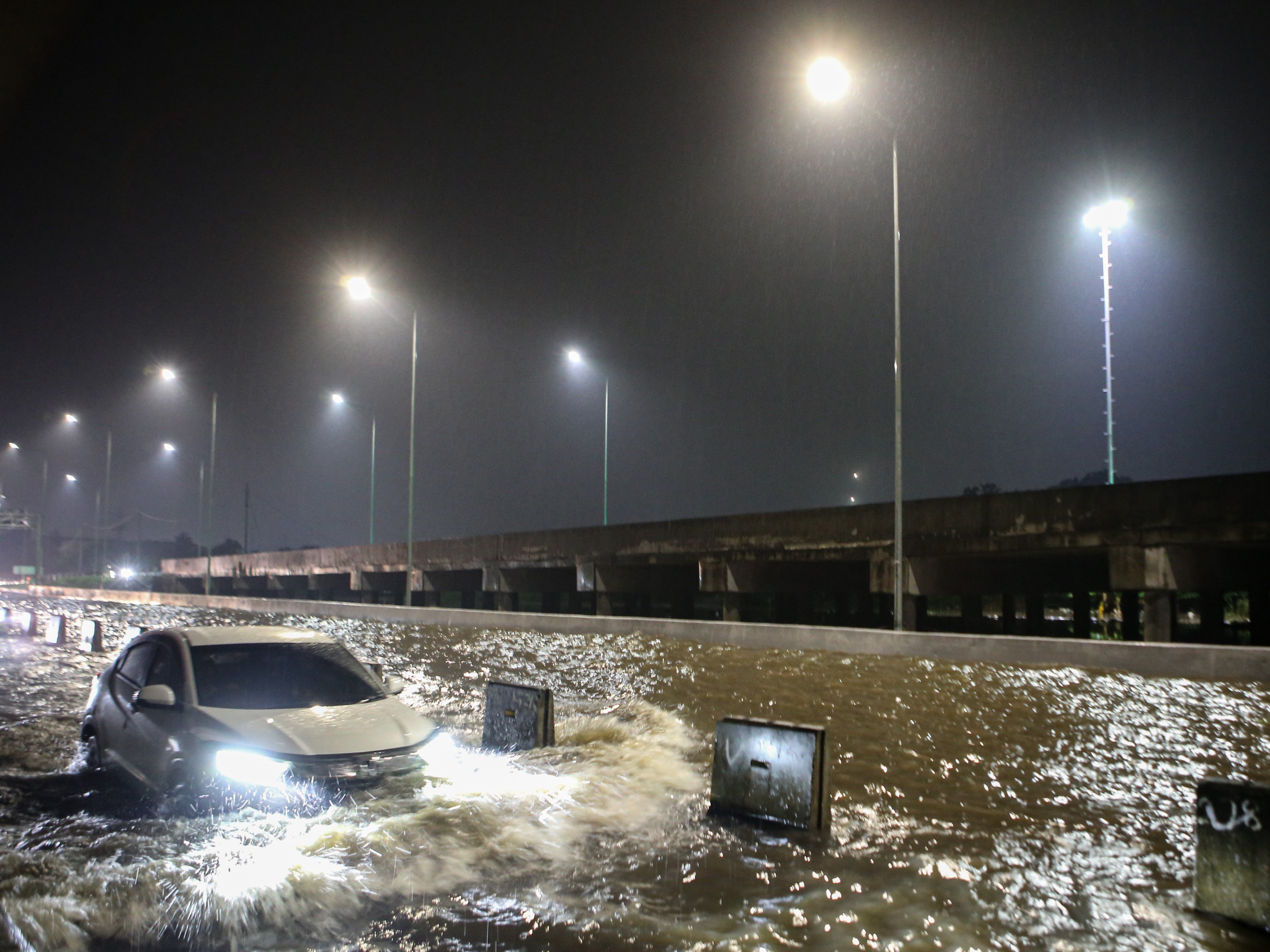 Mobil melintasi banjir di ruas Tol Pondok Aren-Serpong, Kota Tangerang Selatan, Banten, Selasa (4/10/2022).
