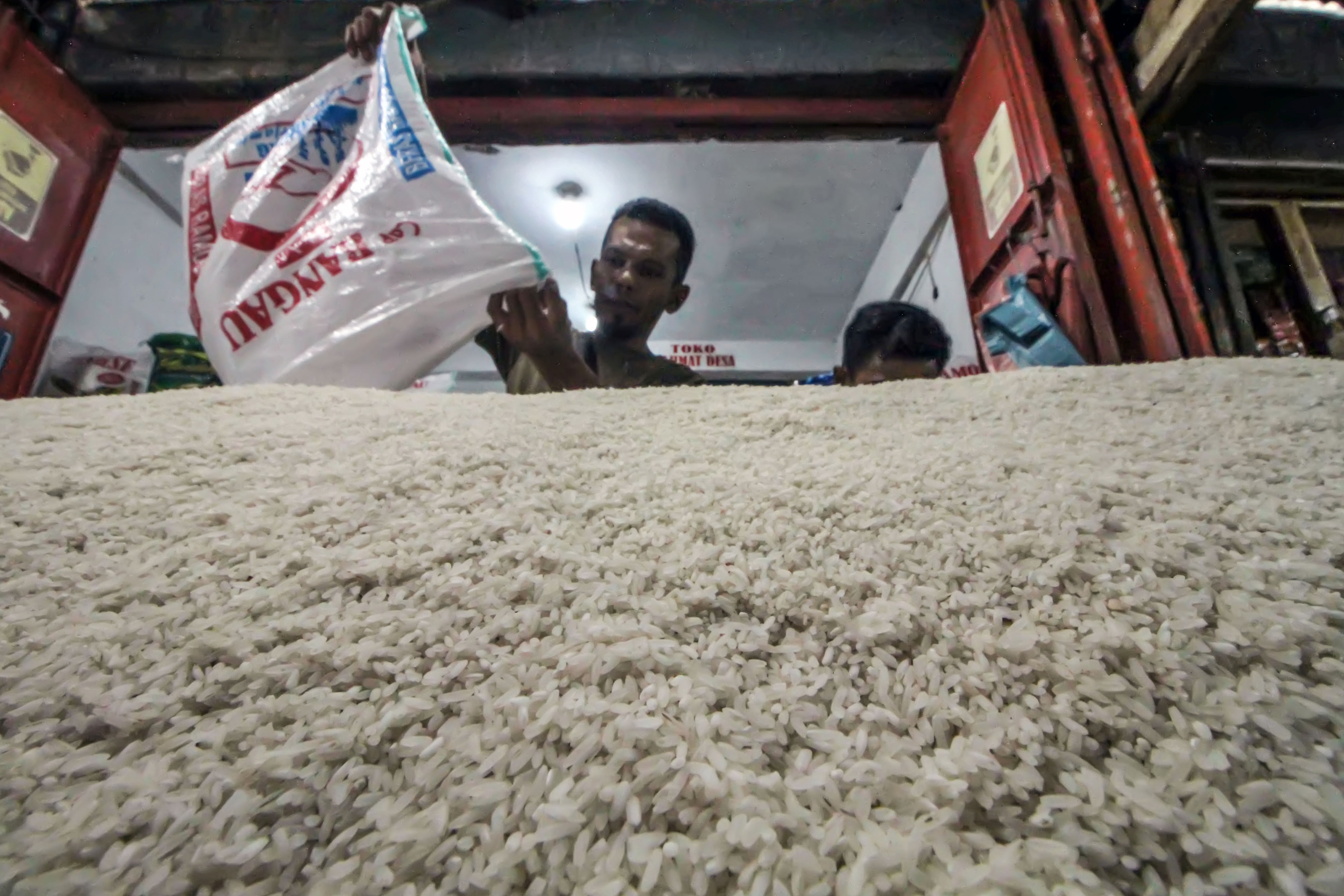 Penjual menuangkan beras eceran