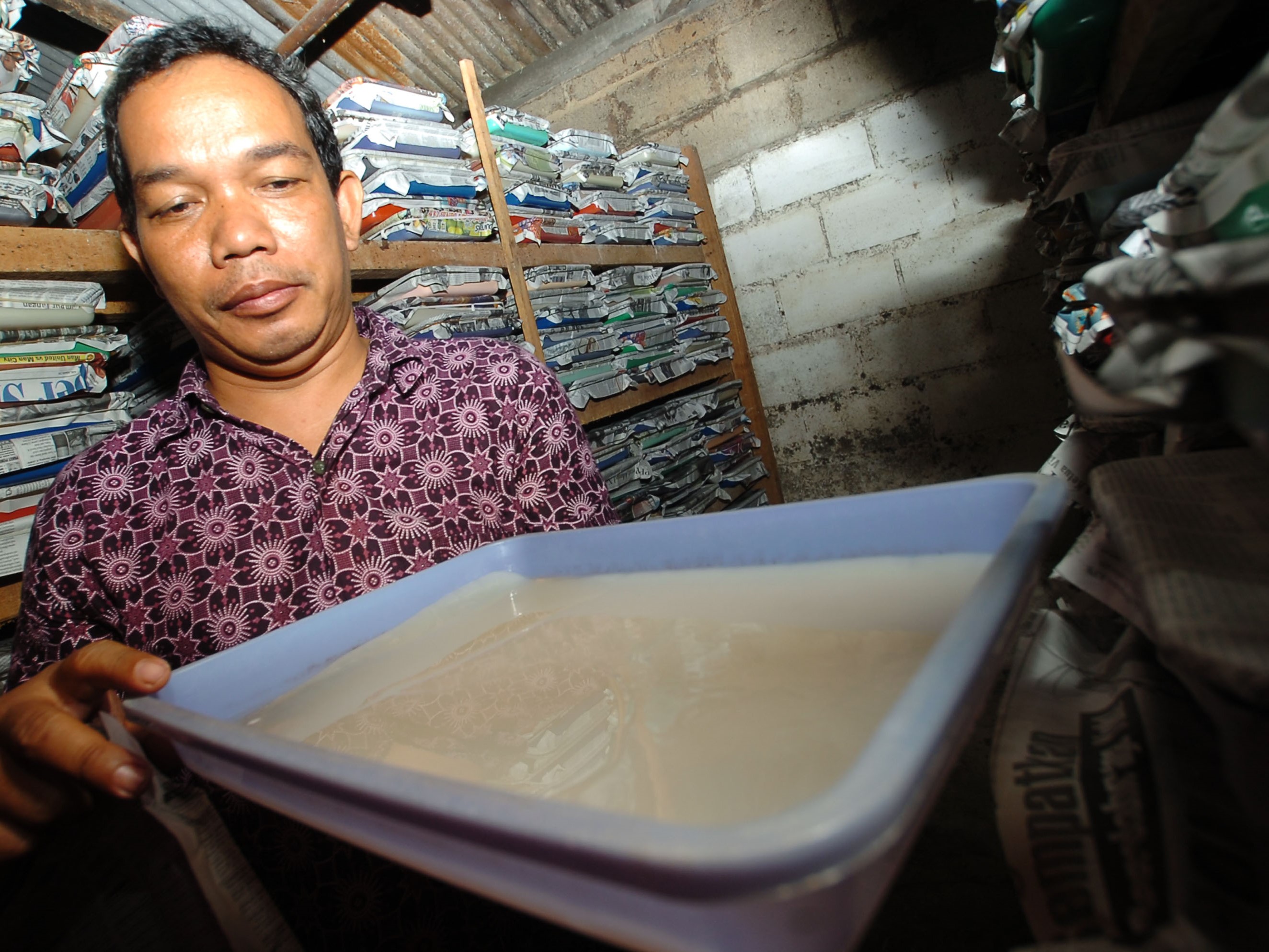 Perajin memeriksa hasil permentasi sari kelapa (nata de coco) di Cingjing, Ciamis, Jawa Barat.